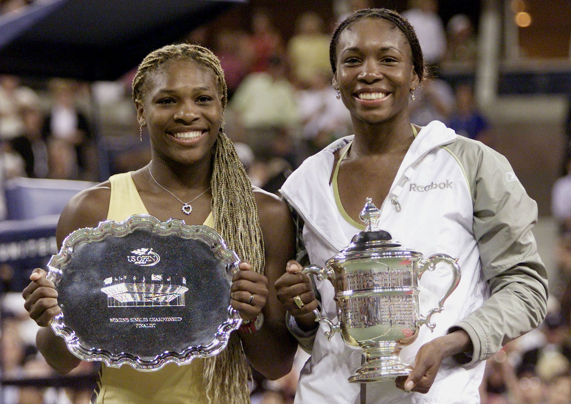 Venus Williams and Serena Williams pose at the 2001 US Open trophy ceremony