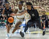 Lance Jones #55 of the Purdue Boilermakers and A.J. Hoggard #11 of the Michigan State Spartans reach for the ball during the second half .