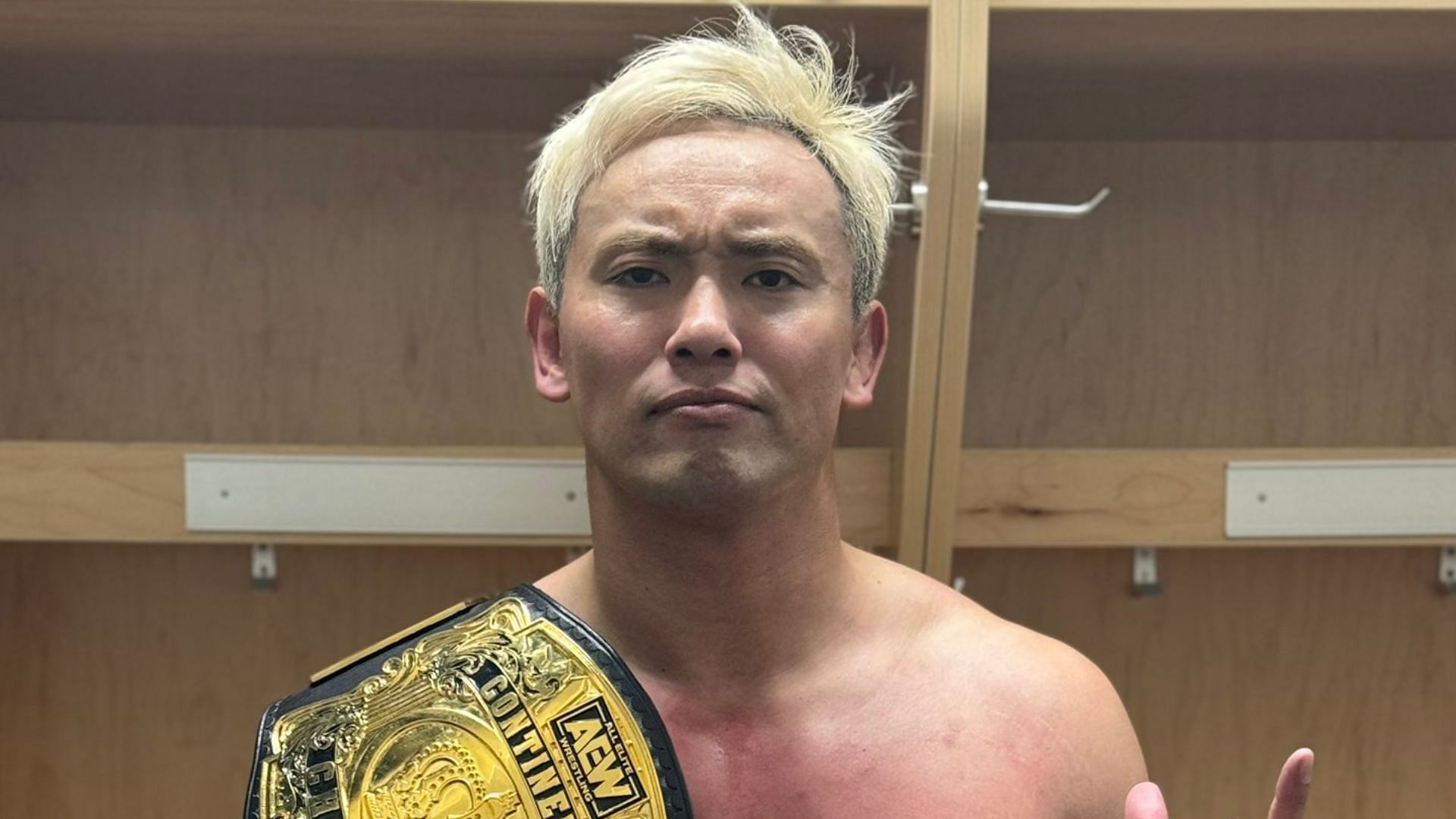 Kazuchika Okada posing in the locker room after his title win on AEW Dynamite.
