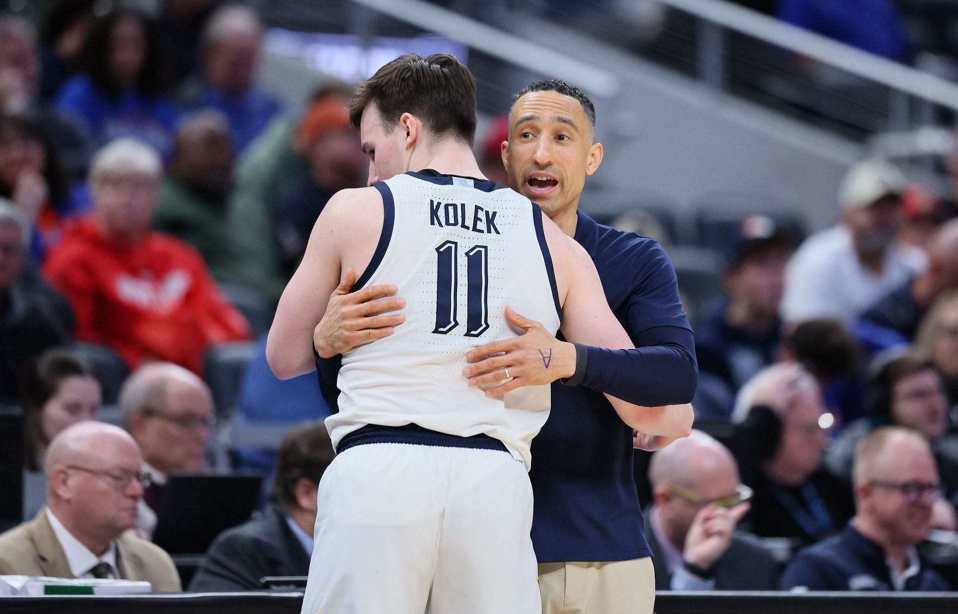 Shaka Smart the head coach of the Marquette Golden Eagles gives a hug to Tyler Kolek.