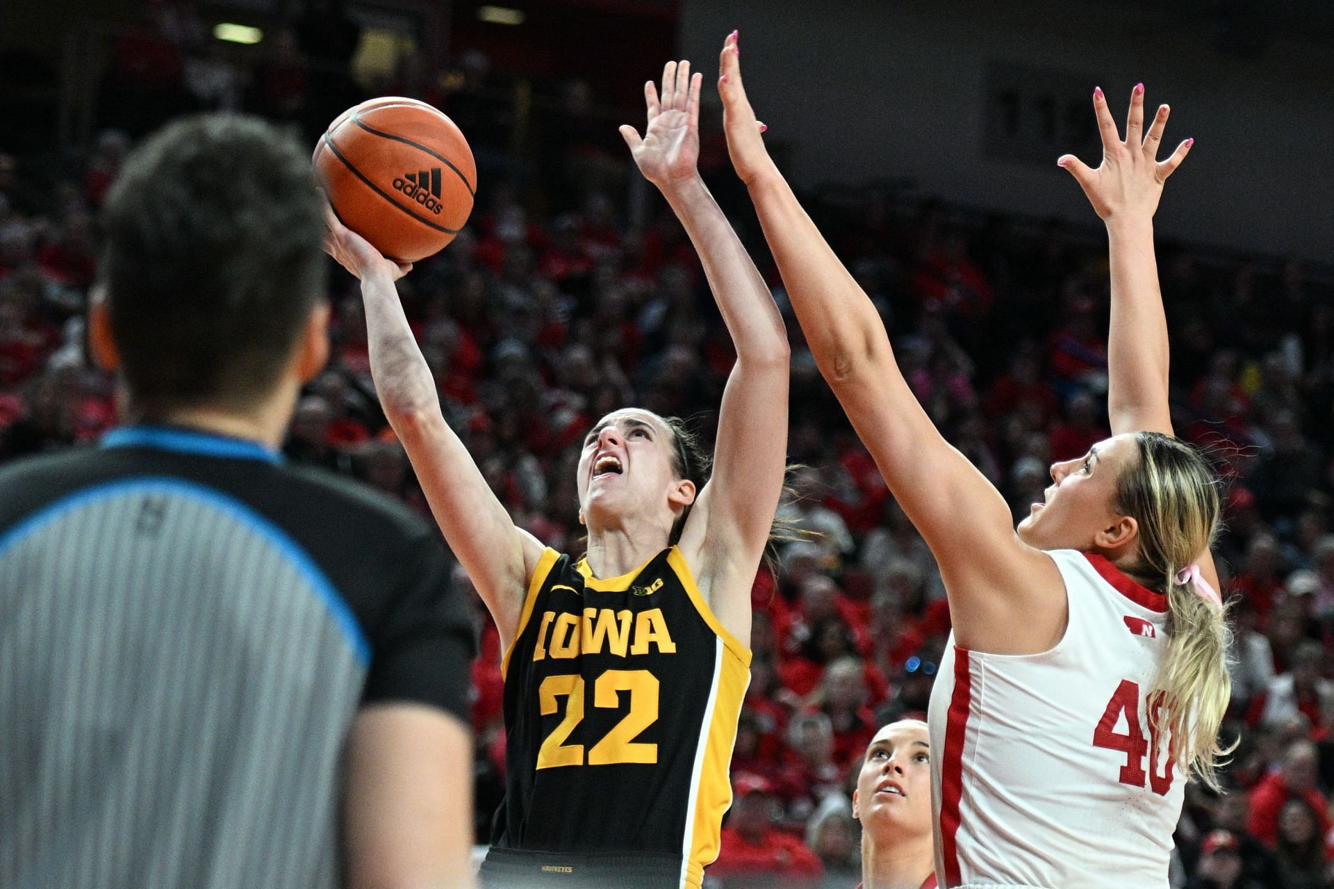 Caitlin Clark #22 of the Iowa Hawkeyes tries to score against Alexis Markowski #40 of the Nebraska Cornhuskers