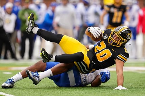 Cody Schrader #20 of the Missouri Tigers is tackled by Trevin Wallace #32 of the Kentucky Wildcats