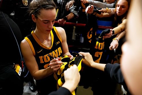 Caitlin Clark signing an autograph for a fan