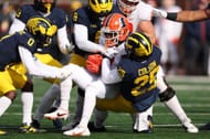 Isaiah Williams #1 of the Illinois Fighting Illini is tackled by Junior Colson #25 and Derrick Moore #8 of the Michigan Wolverines