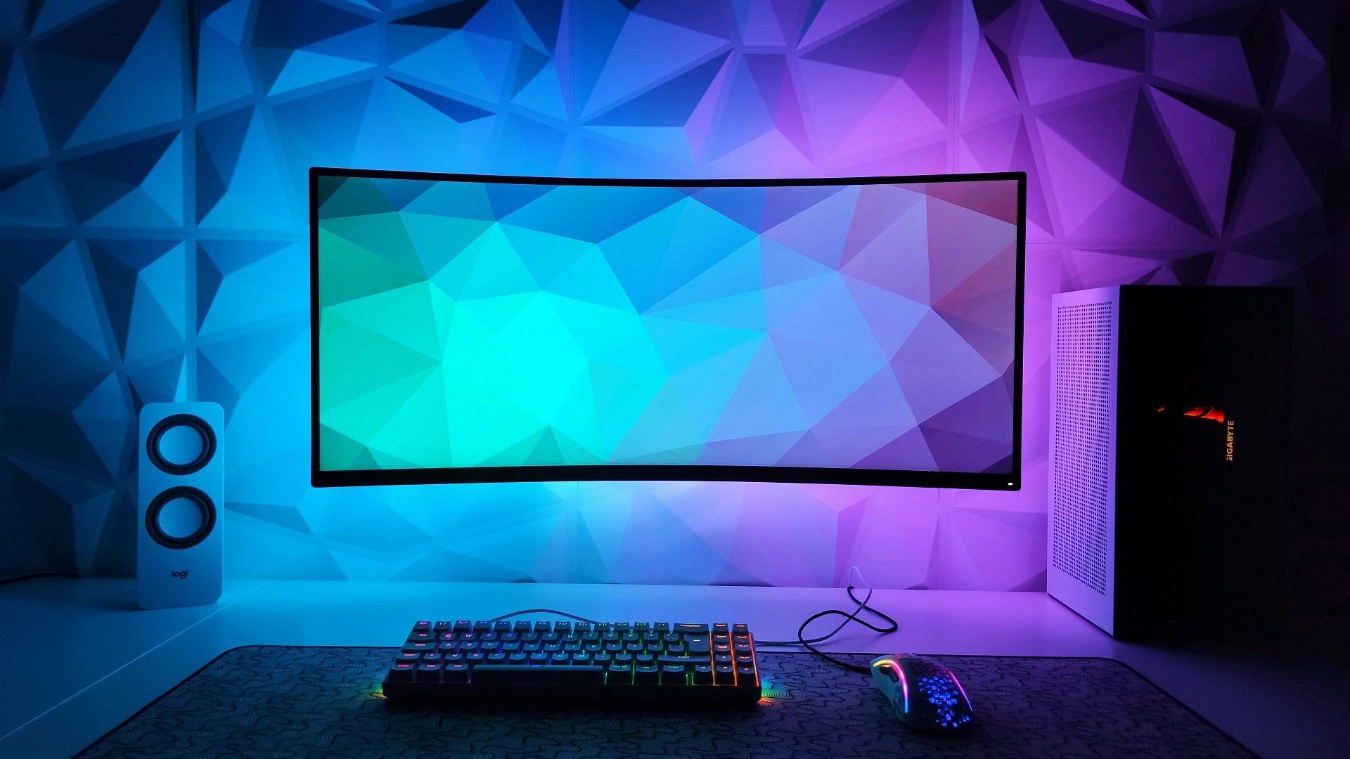 A VESA-mounted ultrawide monitor with RGB LEDs behind it