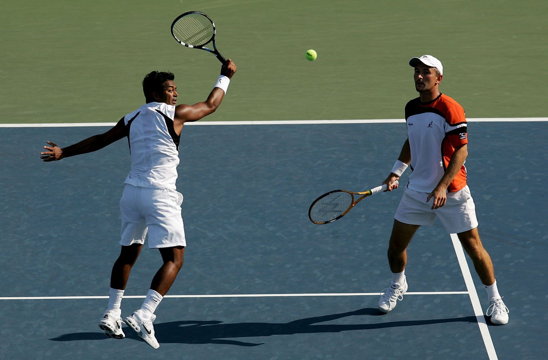 Martin Damm (R) looks on as Leander Paes hits a volley at the 2006 US Open