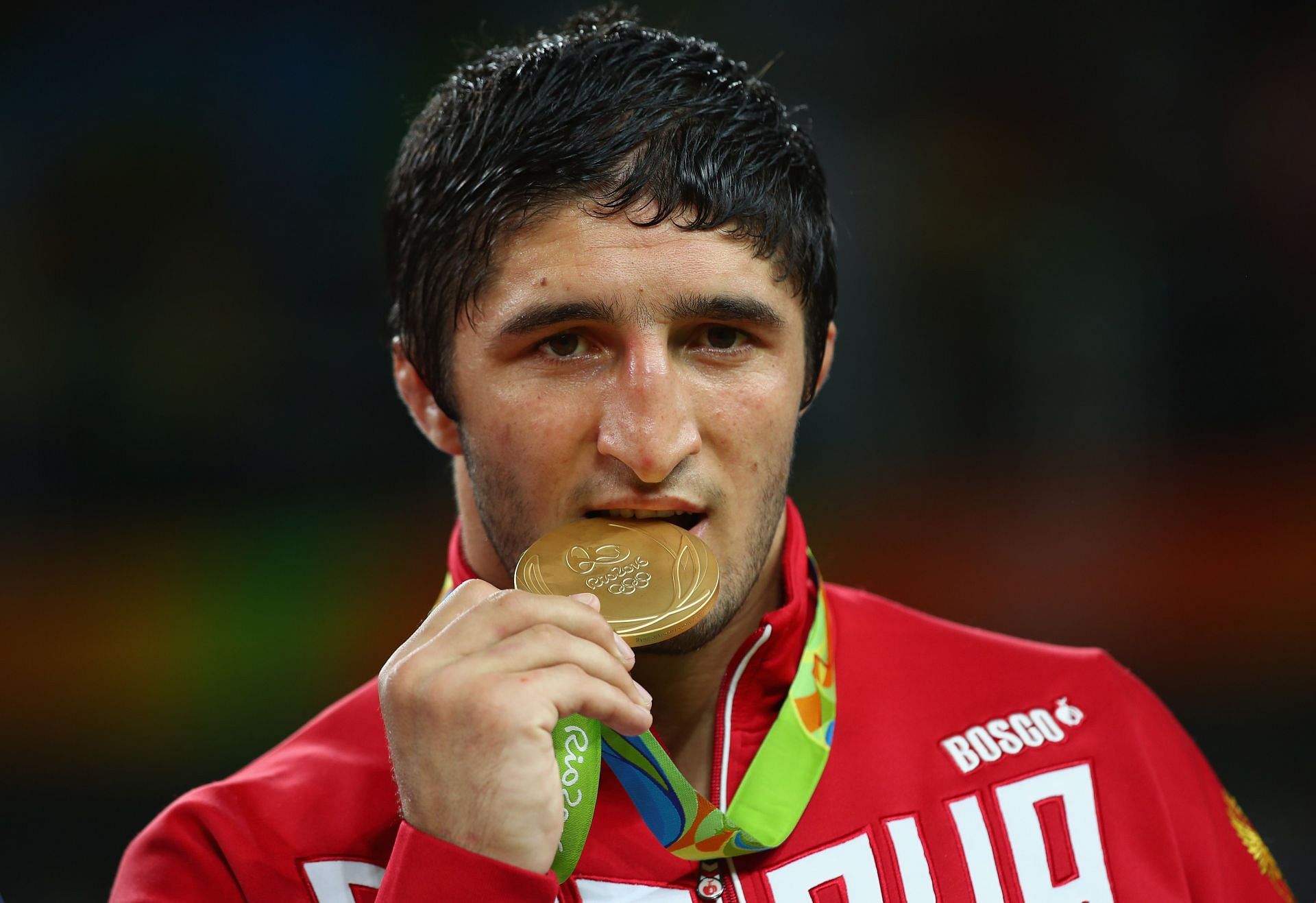 Abdulrashid Sadulaev poses on the podium during the medal ceremony for the Men&#039;s Freestyle 86kg Wrestling at the 2016 Olympic Games in Rio de Janeiro, Brazil