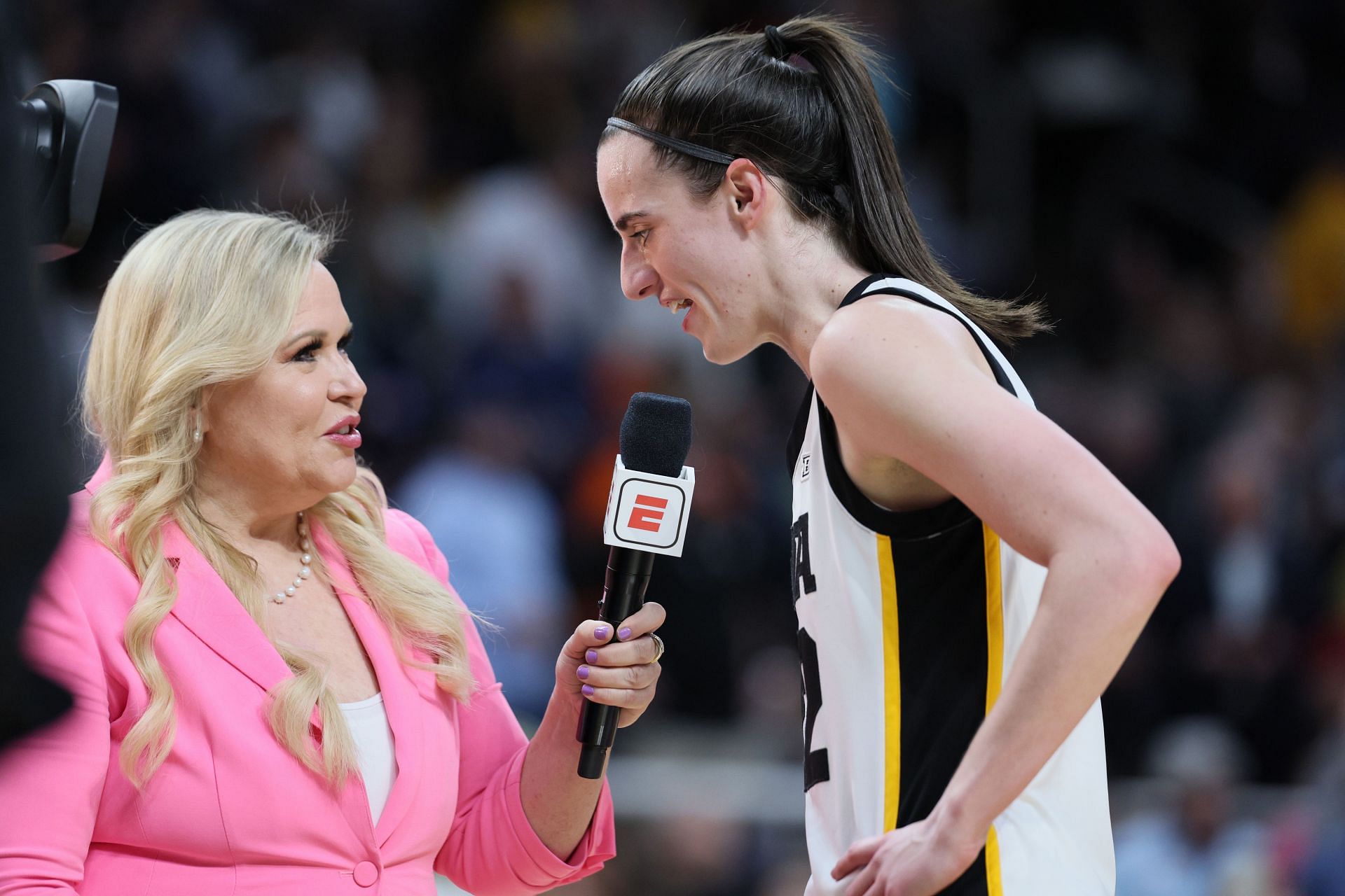 Caitlin Clark #22 of the Iowa Hawkeyes talks with ESPN&#039;s Holly Rowe during halftime of a game against the LSU Tigers in the Elite 8 round.