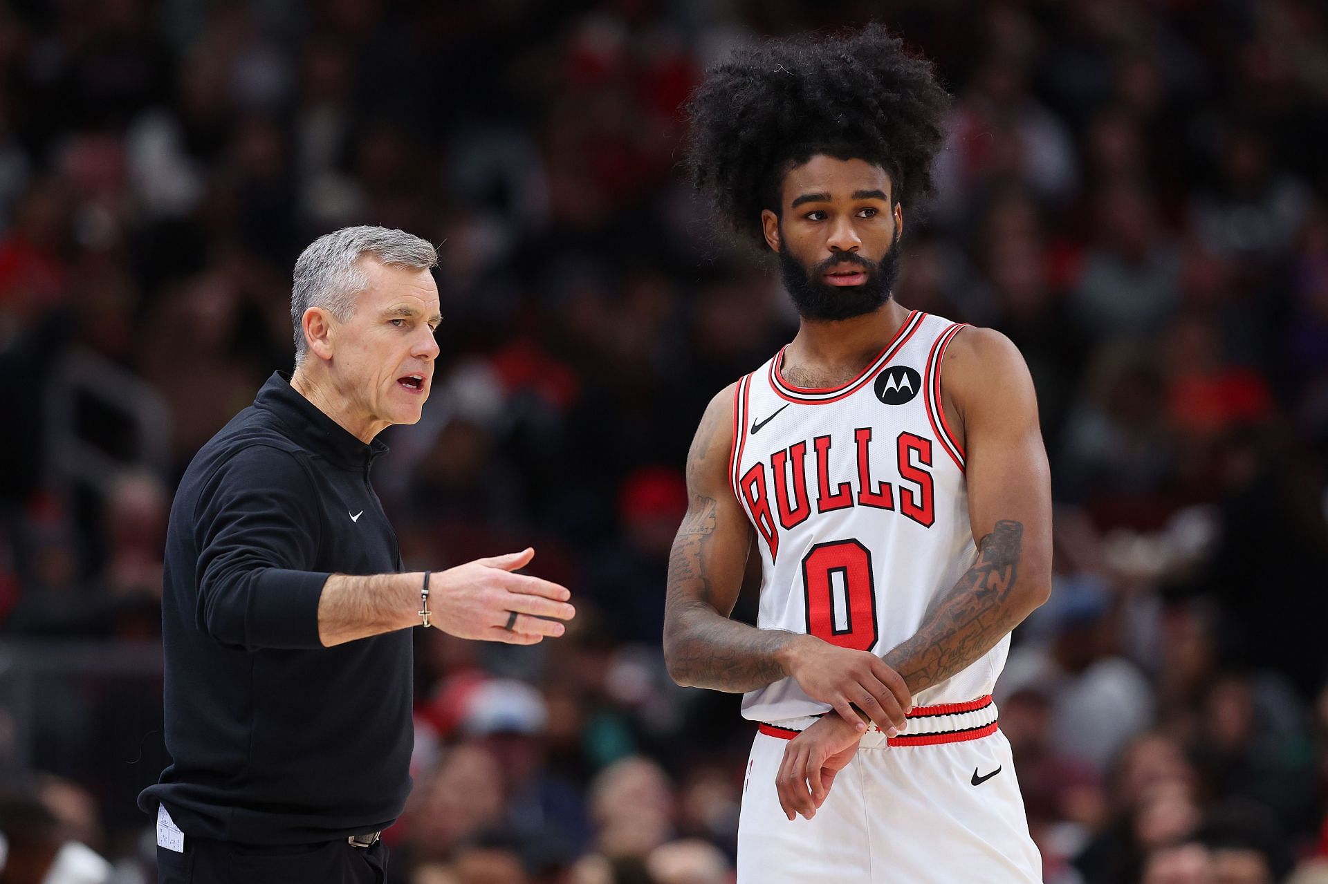 Chicago Bulls coach Billy Donovan talks to guard Coby White.
