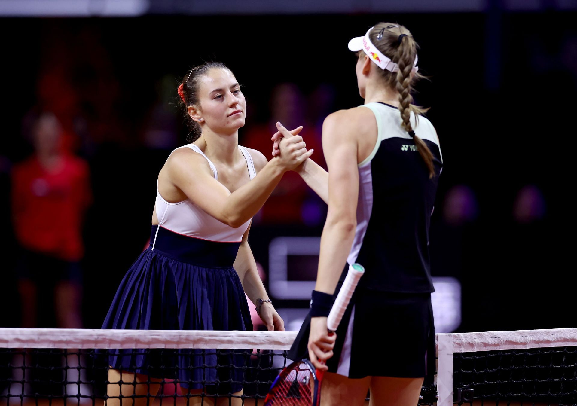 Marta Kostyuk (L) shakes hands with Elena Rybakina