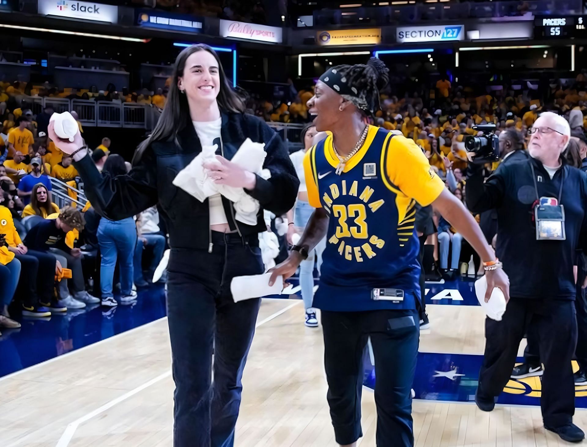 Teammates Caitlin Clark and Erica Wheeler throwing away t-shirts at the recent Indiana Pacers home game. 