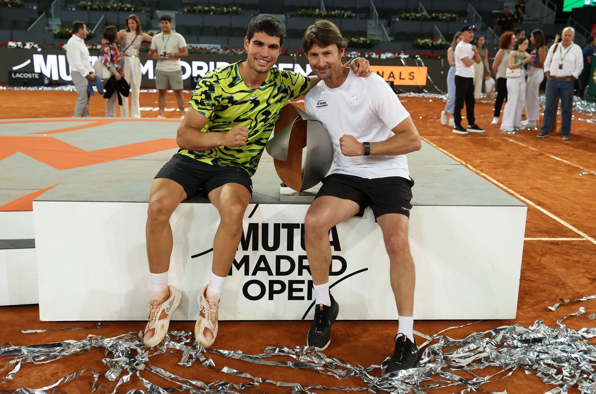 Carlos Alcaraz (L) and Juan Carlos Ferrero (R) posing with the 2023 Mutua Madrid Open trophy