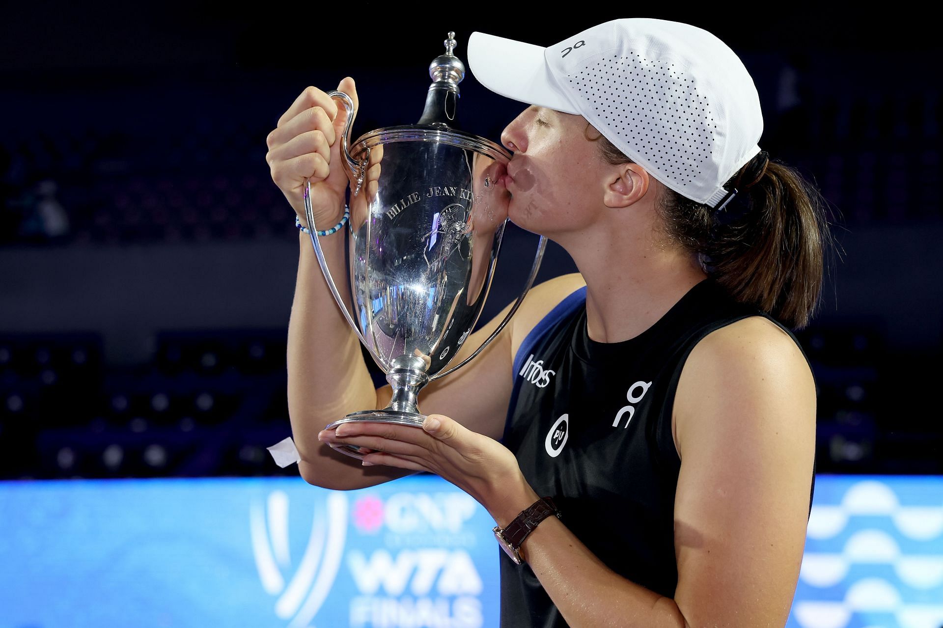 Iga Swiatek kissing the 2023 WTA Finals trophy