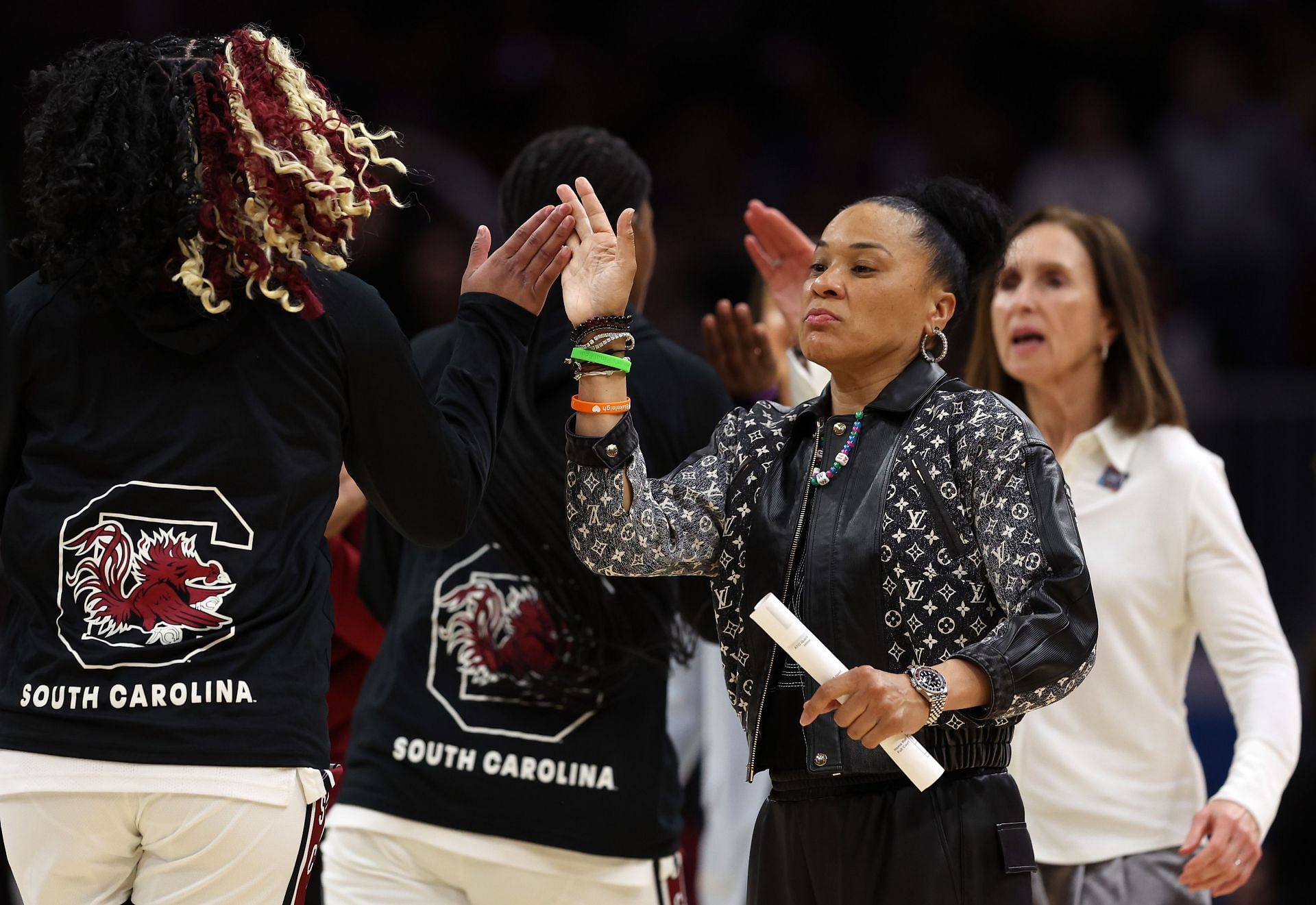 South Carolina coach Dawn Staley sharing high-fives with her team.