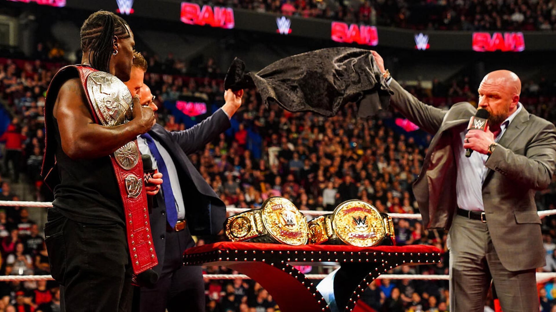 Triple H unveiled the World Tag Team titles on RAW with the help of Adam Pearce.