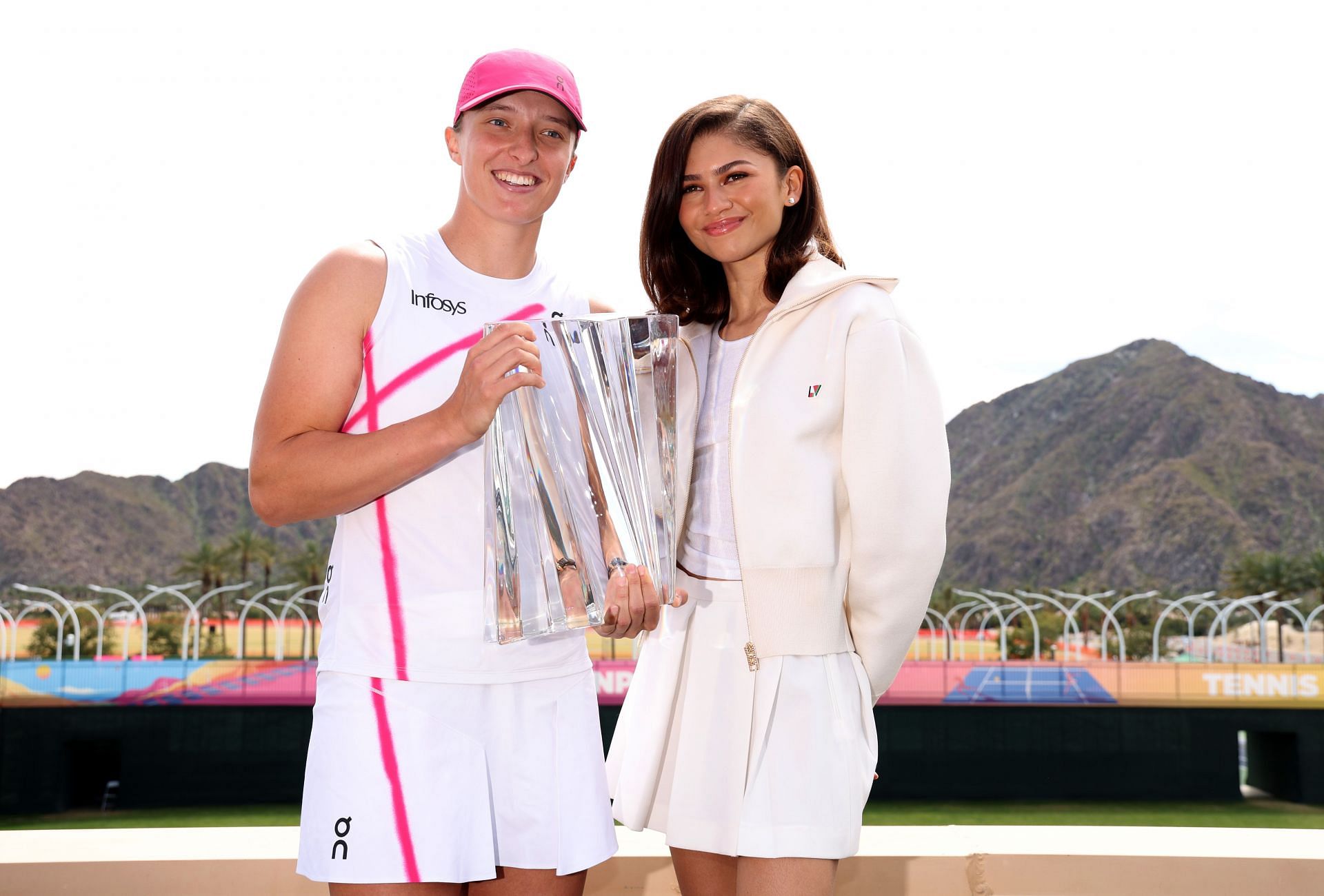 Iga Swiatek (L) with the BNP Paribas Open trophy, poses with Zendaya (R)