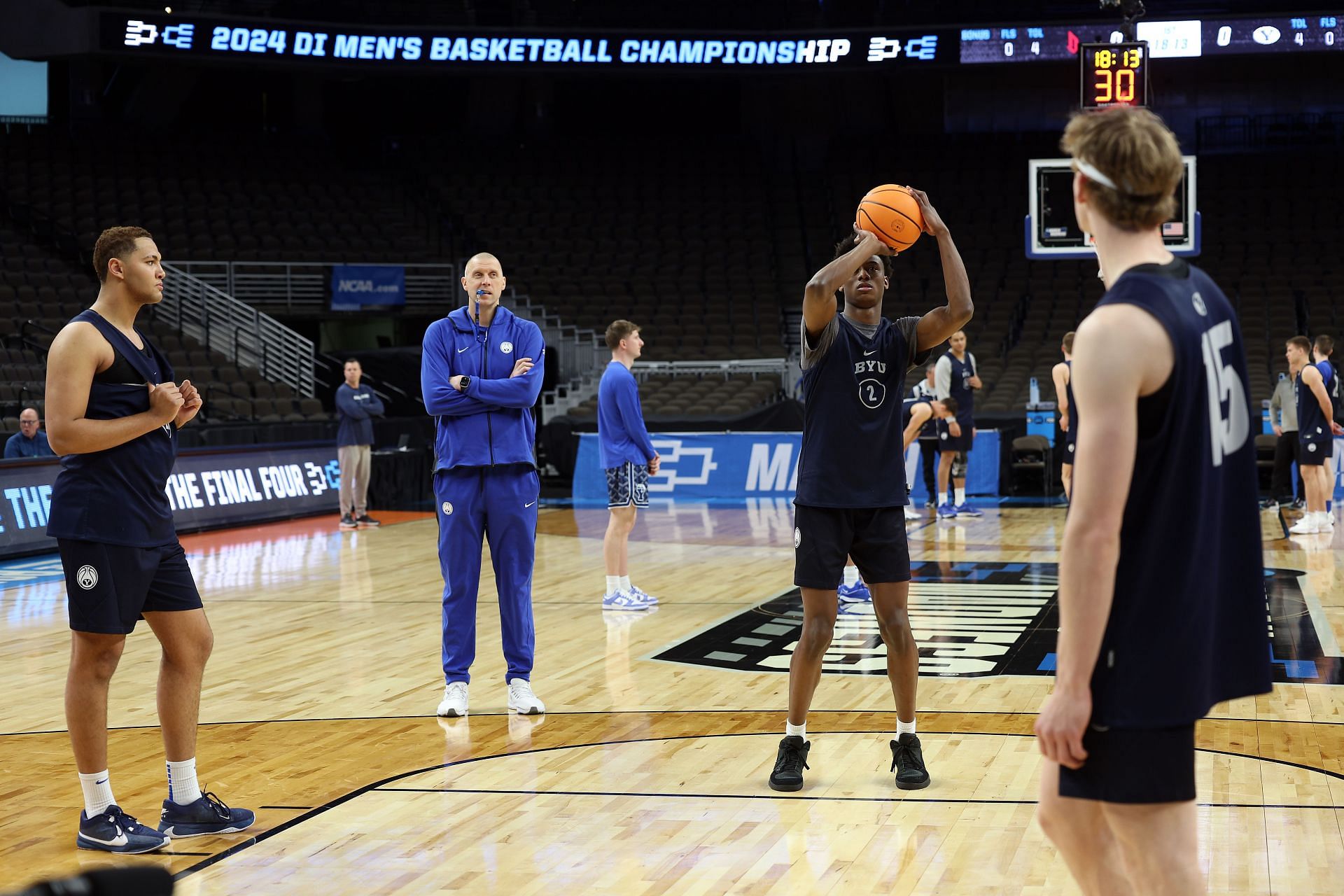 Jaxson Robinson #2 of the BYU Cougars shoots a free throw as head coach Mark Pope watches during practice.