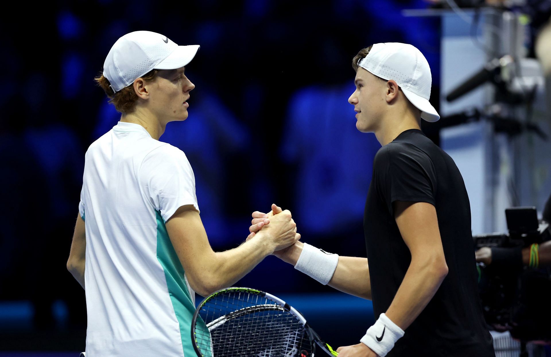 Jannik Sinner (L) and Holger Rune shake hands.