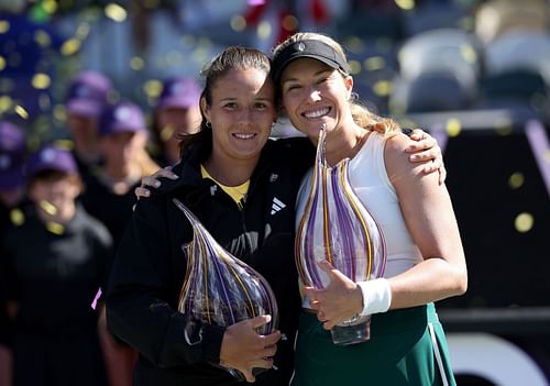 Daria Kasatkina (L) and Danielle Collins pose with their respective trophies at the Charleston Open 2024.