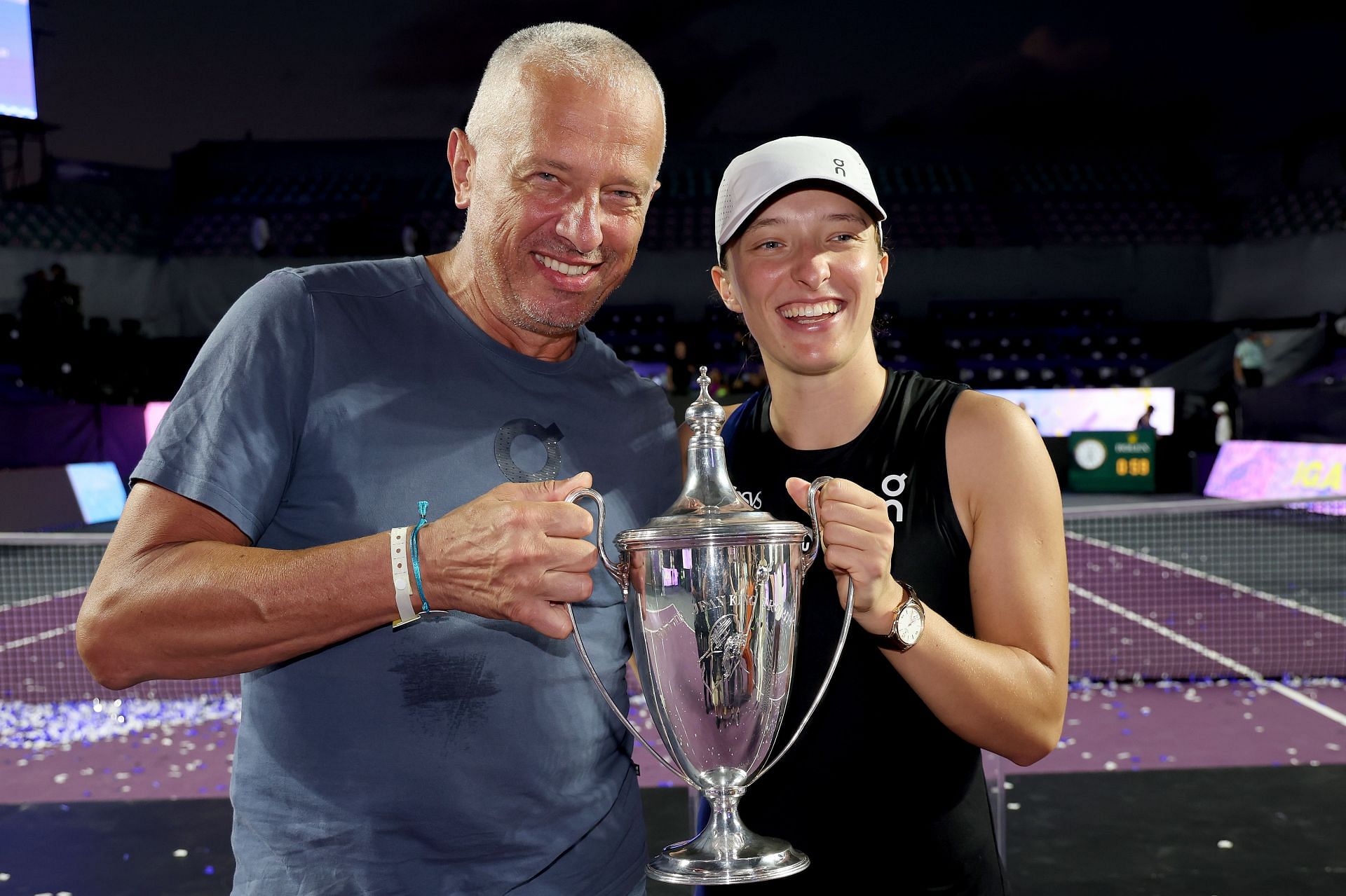 Tomasz Swiatek (L) and Iga Swiatek (R) posing with the 2023 WTA Finals trophy