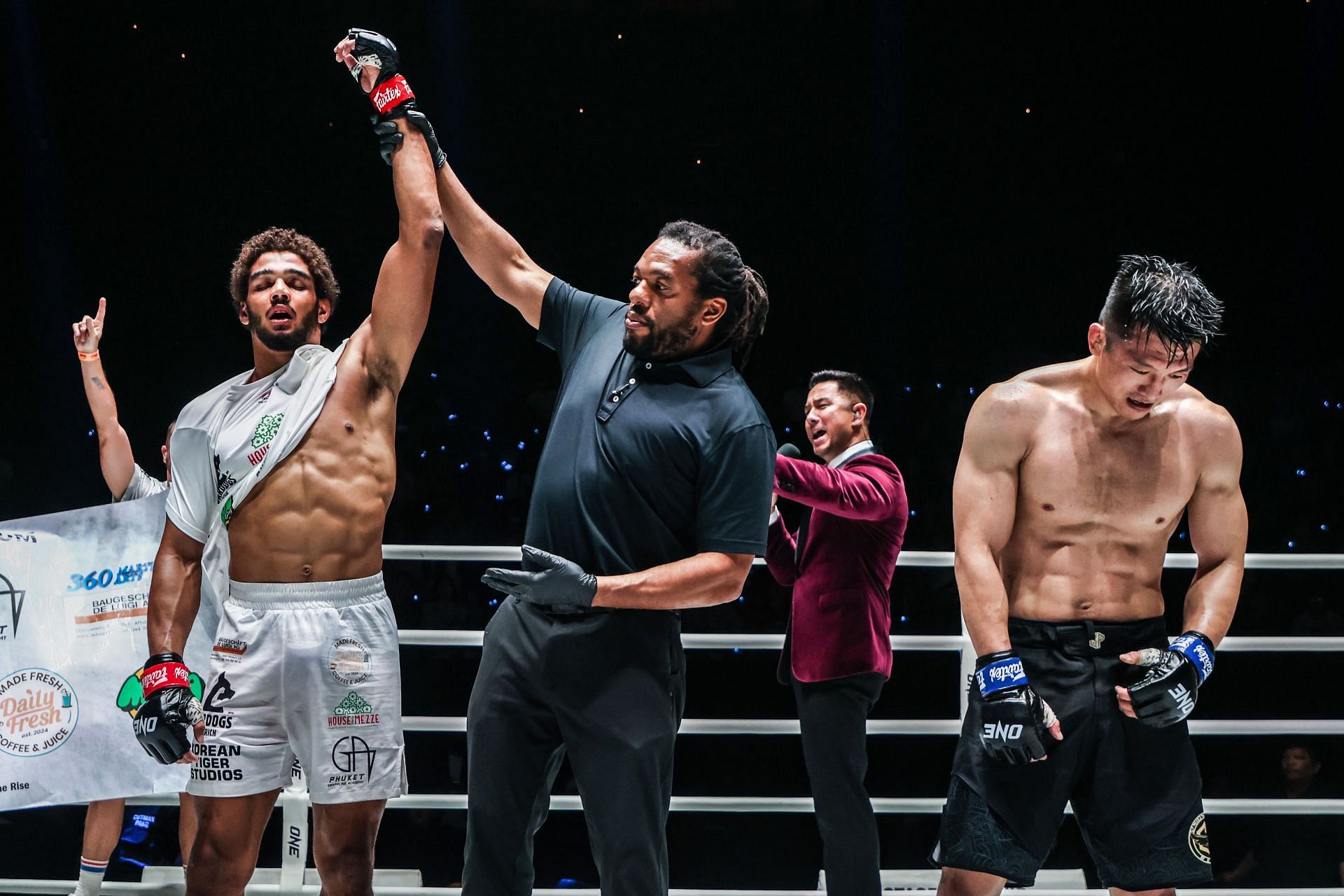 Referee Herb Dean raises Maurice Abevi&#039;s hand after his win over Zhang Lipeng.