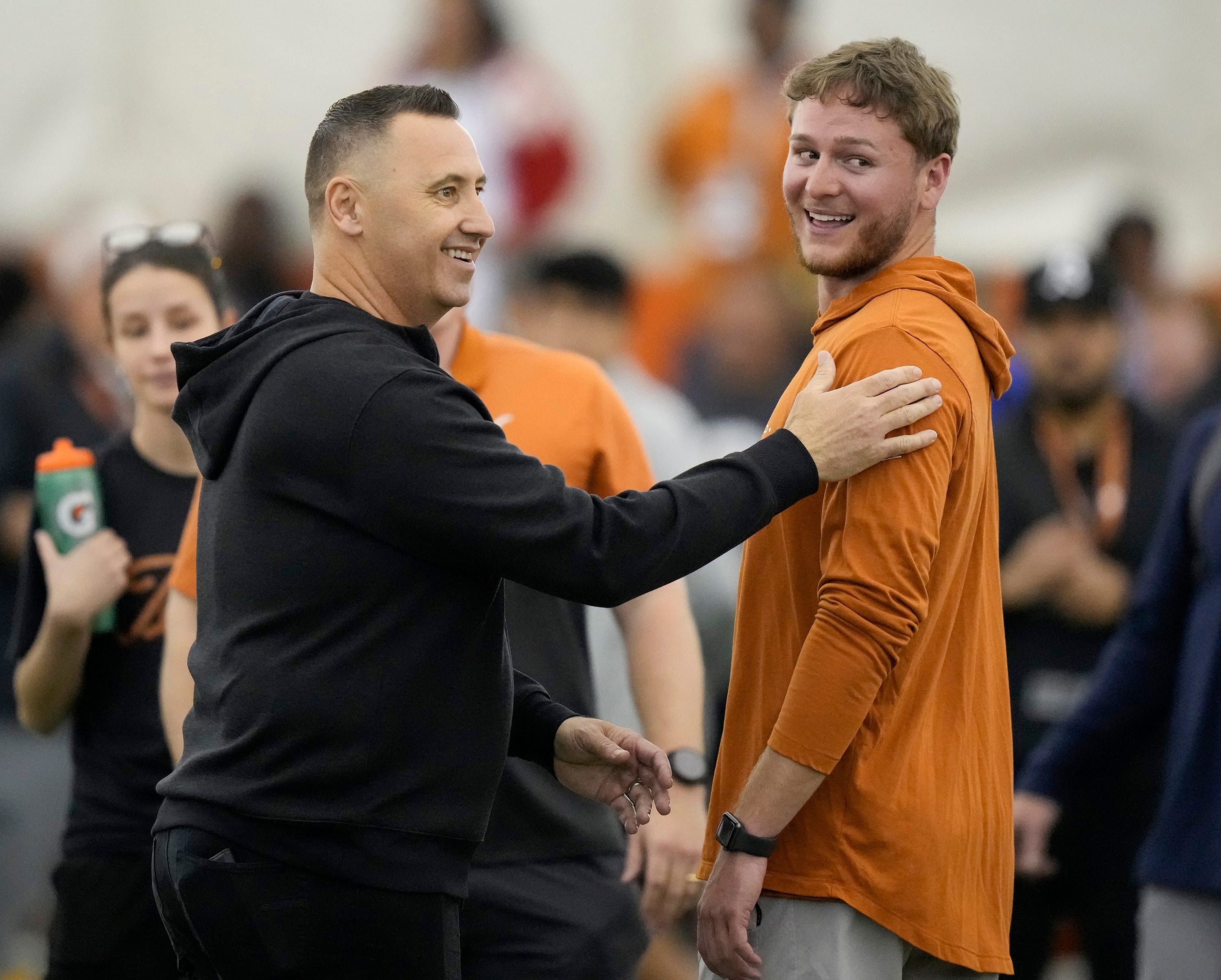 Head coach Steve Sarkisian greets quarterback Quinn Ewers.