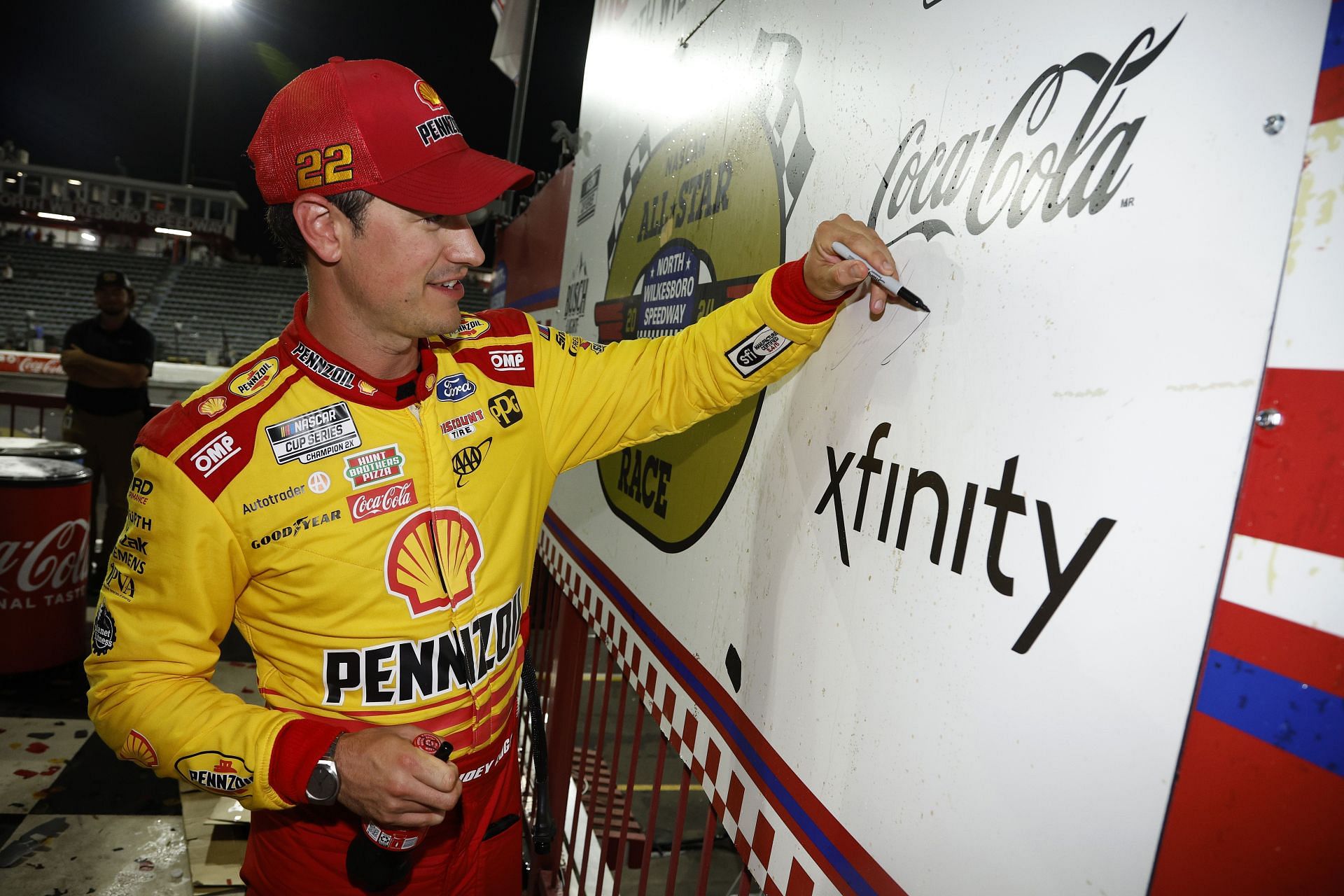 Joey Logano signs the victory lane backdrop after winning his second NASCAR All-Star Race
