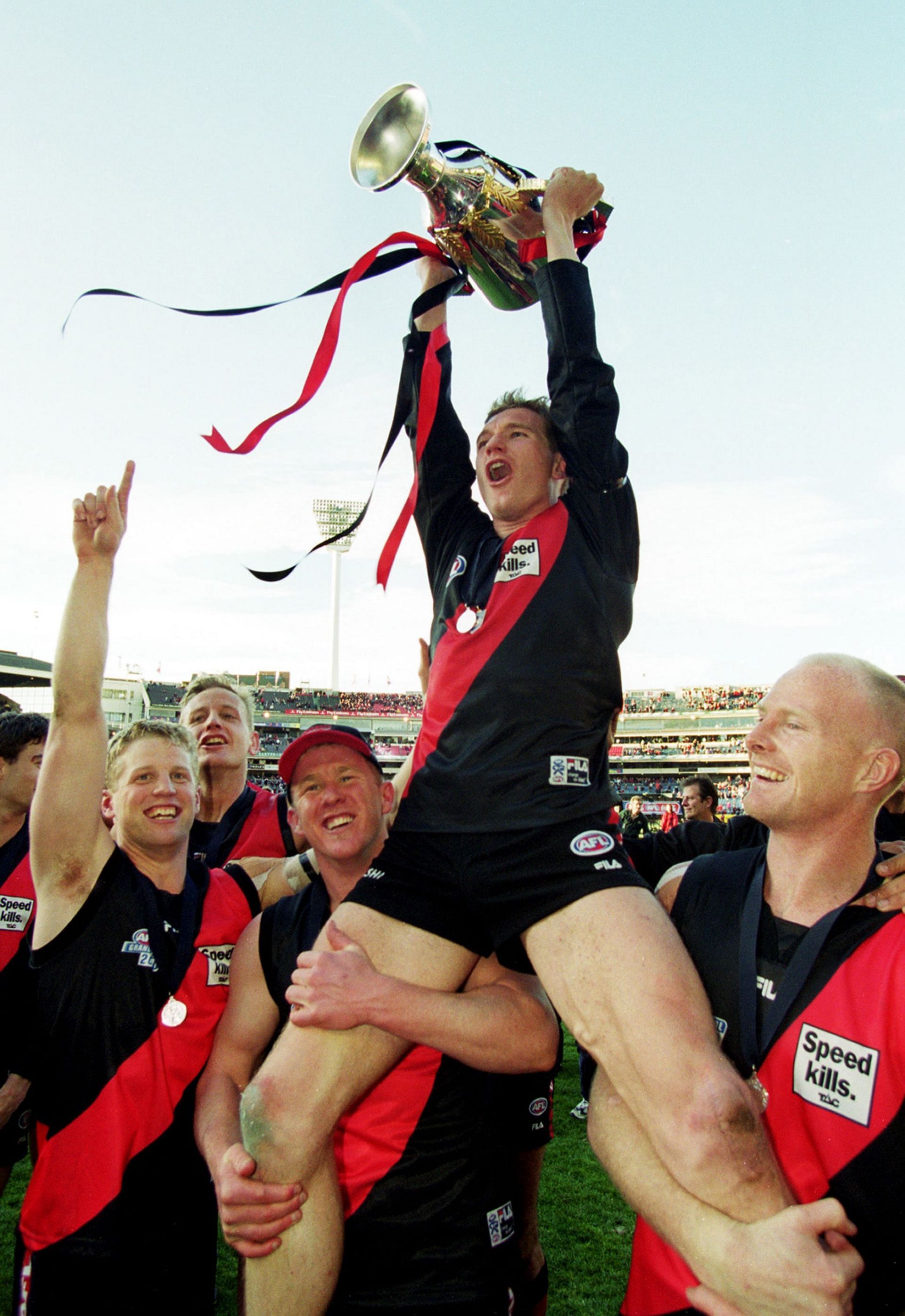 James Hird celebrates on the shoulders of Jason Johnson and Dean Wallis after their win in the AFL Grand Final match in the 2000 season