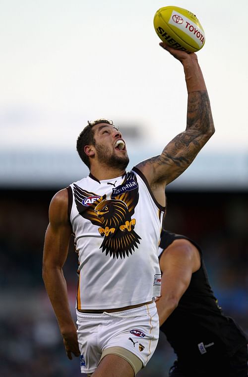 Lance Franklin of the Hawks marks the ball