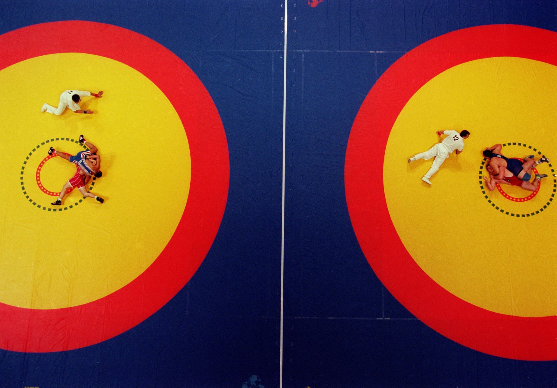 A double pin takes place on two wrestling mats simutaneously 