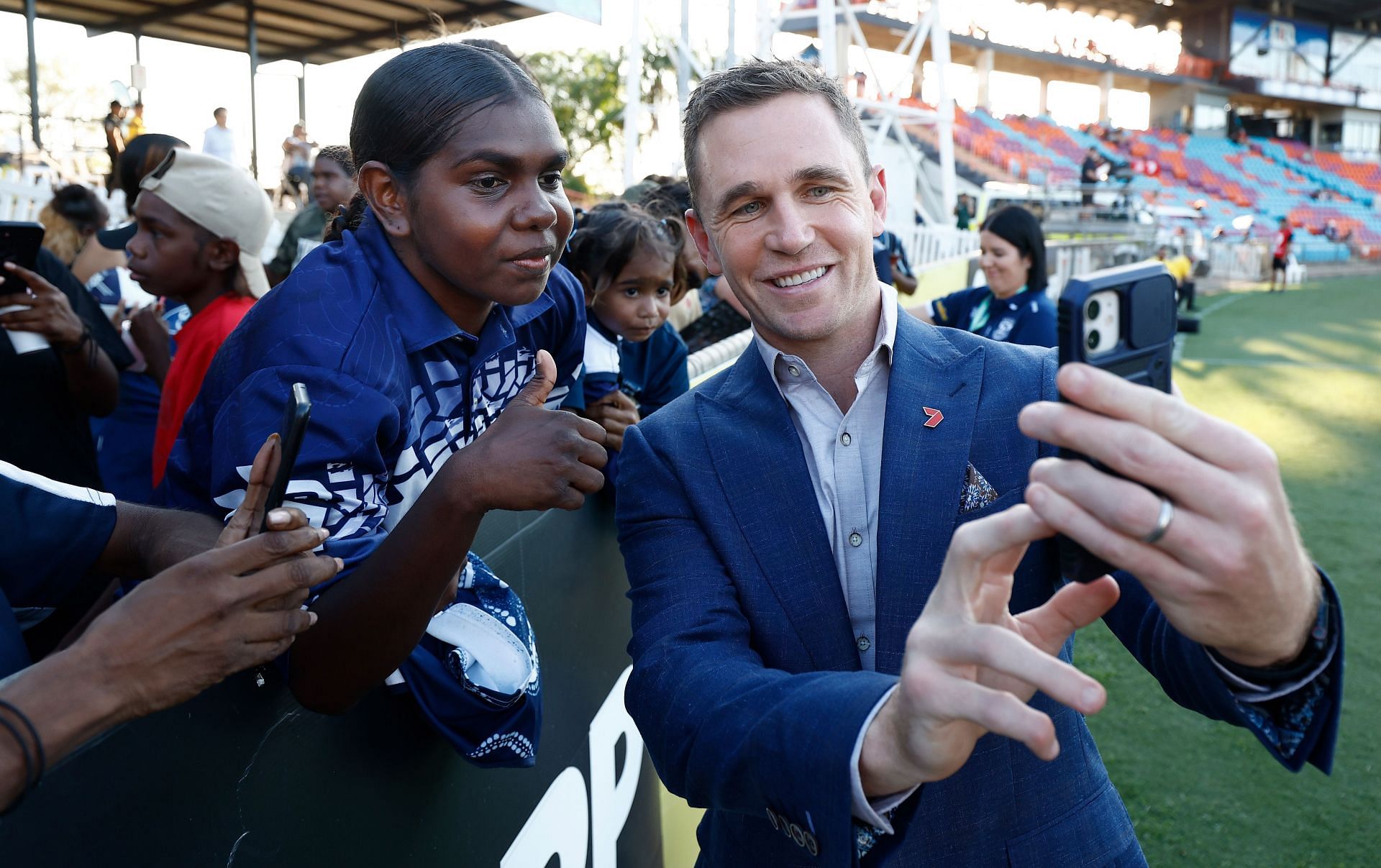 Joel Selwood poses for selfies with Cats fans during the 2024 AFL round-10 match between The Gold Coast SUNS and The Geelong Cats