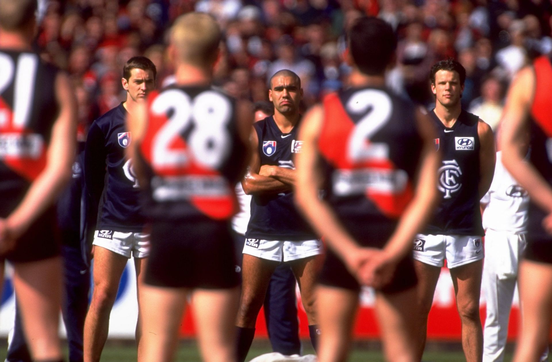 The Carlton &lt;a href=&#039;https://www.sportskeeda.com/afl/carlton-blues&#039; target=&#039;_blank&#039; rel=&#039;noopener noreferrer&#039;&gt;Blues&lt;/a&gt; and Essendon Bombers players line up for the national anthem before the AFL second preliminary final of 1999