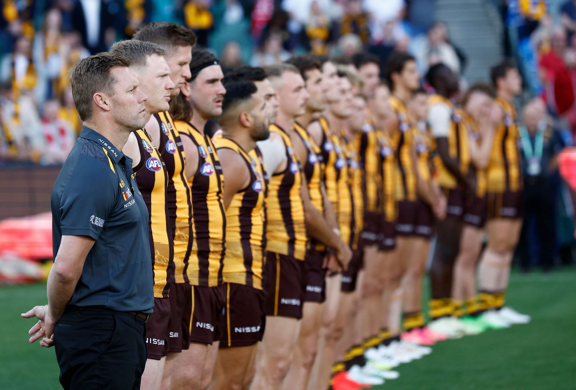 The Hawks pause for the Last Post during the 2024 AFL round seven match