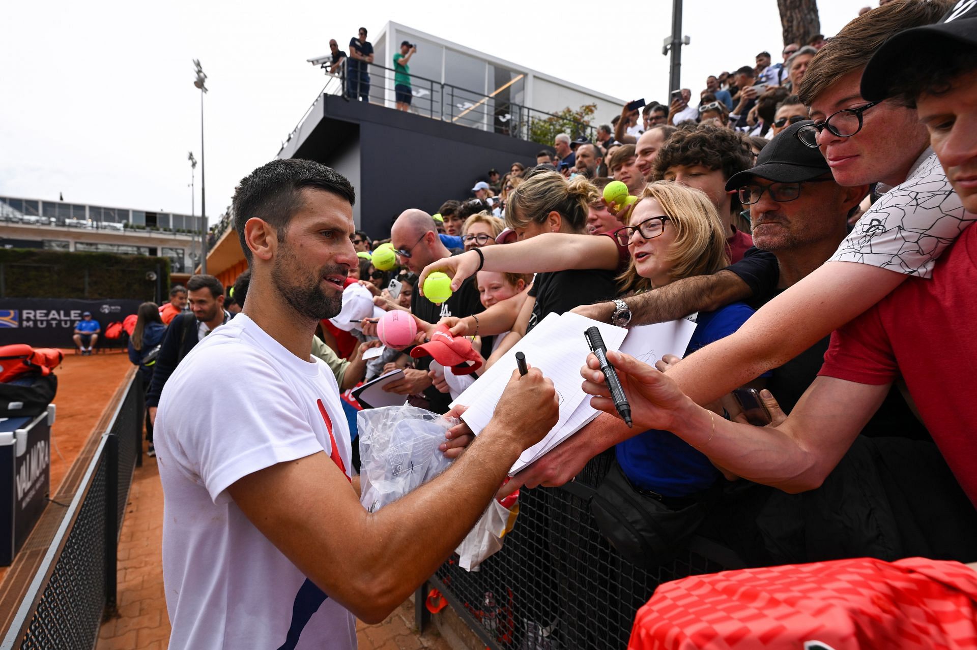 Novak Djokovic signs autographs during a practice session ahead of the Italian Open 2024
