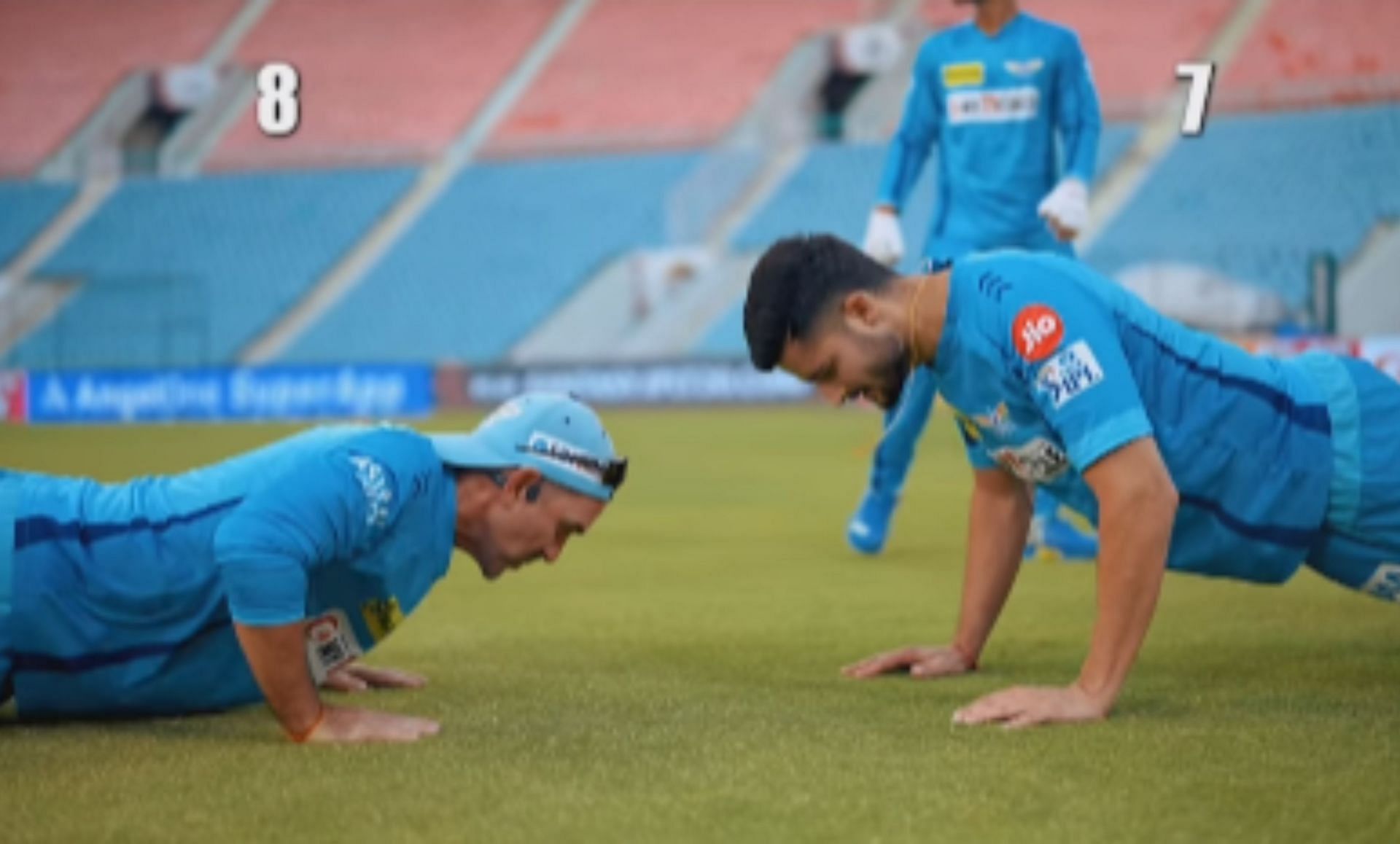 LSG head coach Justin Langer doing push ups with a player in the team camp. 