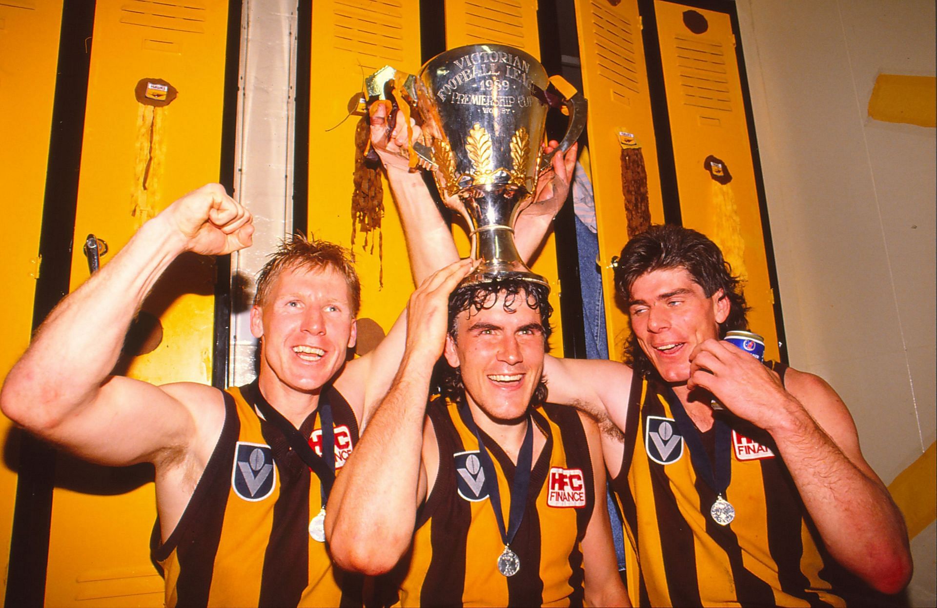 Greg Dean (C) and Gary Ayres (R) of the Hawks celebrate with the trophy following the AFL Grand Final match between Hawthorn Hawks and Geelong Cats