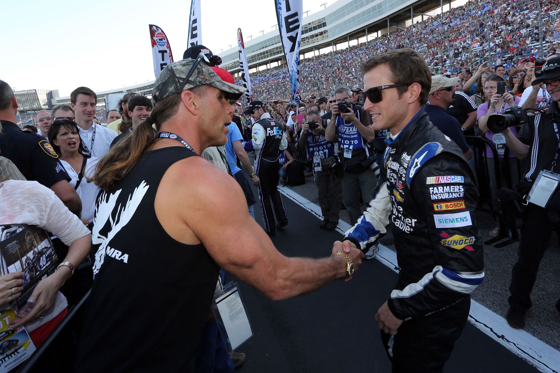WWE Hall of Famer Shawn Michaels (L) shakes hands with Kasey Kahne (R), driver of the #5 Time Warner Cable Chevrolet, prior to the start of the NASCAR Sprint Cup Series NRA 500 at Texas Motor Speedway on April 13, 2013 in Fort Worth, Texas. (Photo by Jerry Markland/Getty Images)