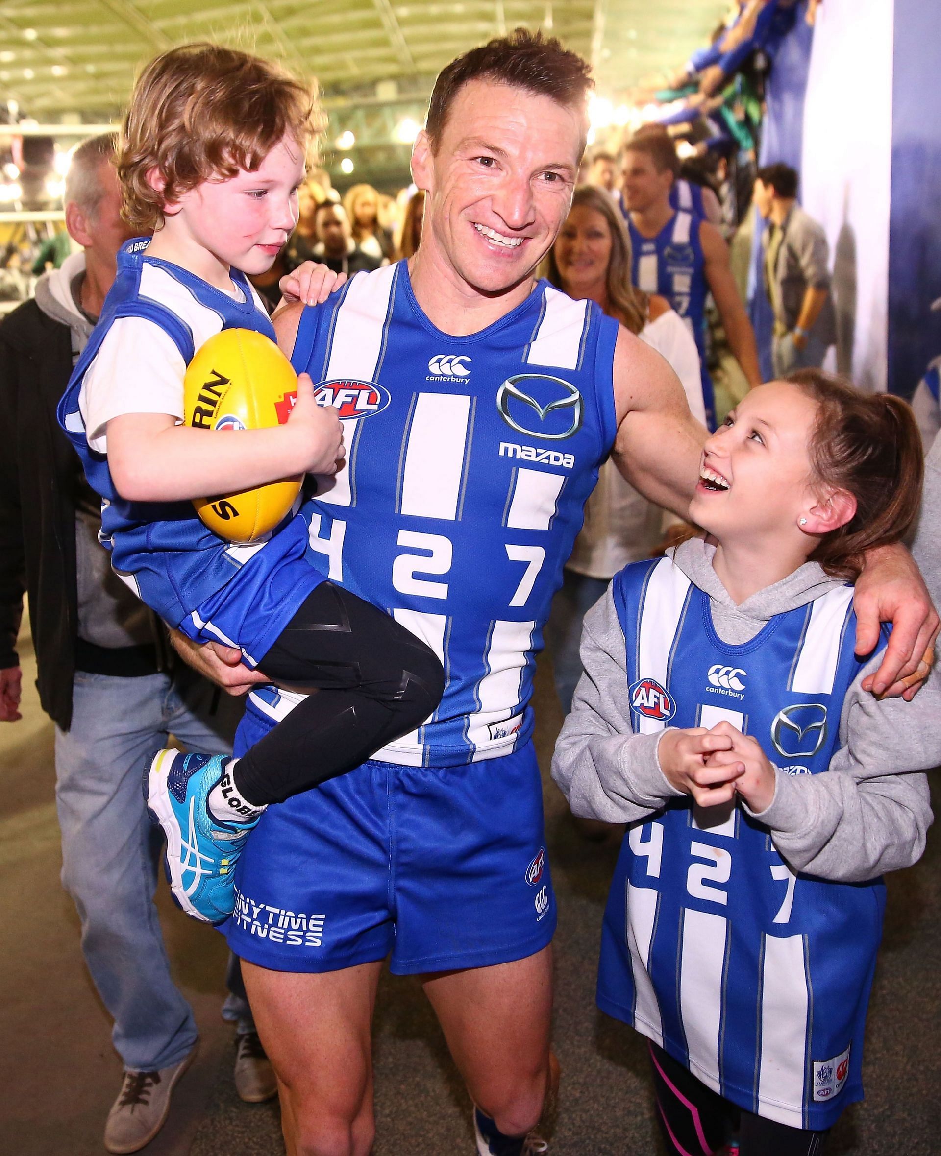 Brent Harvey of the Kangaroos is congratulated by his children Lacie Harvey, Cooper Harvey and Hudson Harvey as he leaves the field