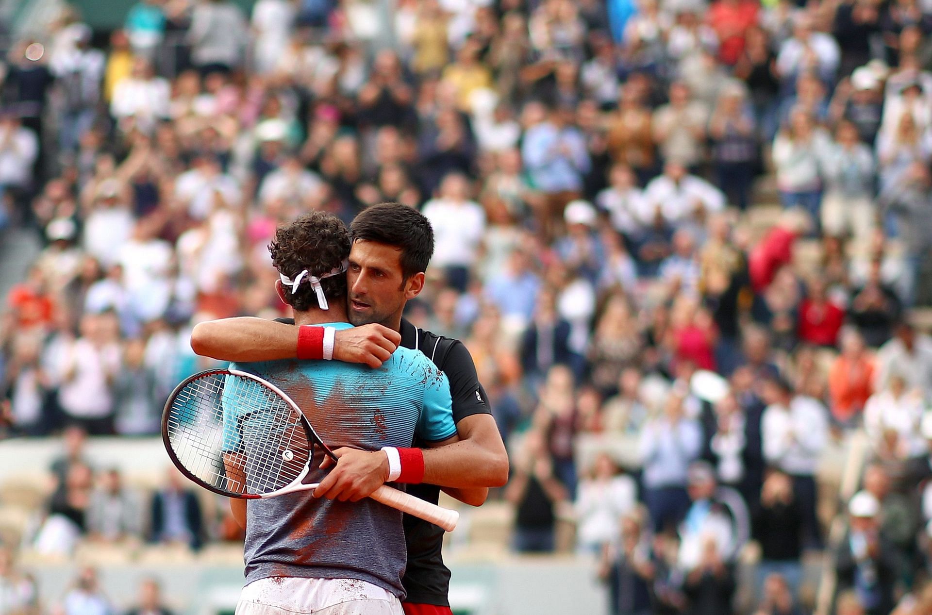 Novak Djokovic hugs Marco Cecchinato at the 2018 French Open