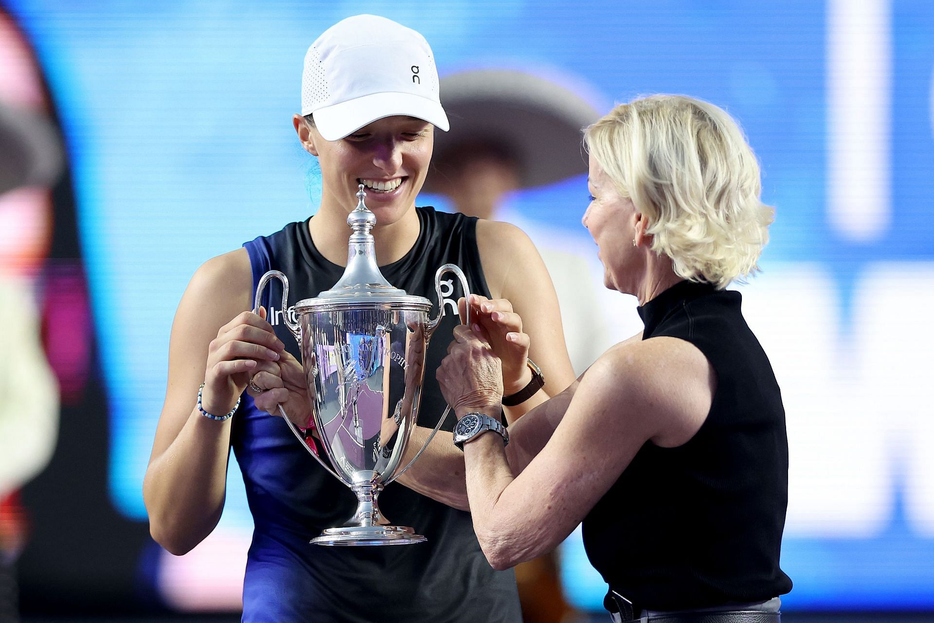 Chris Evert(R) presenting the trophy to Iga Swiatek(L)