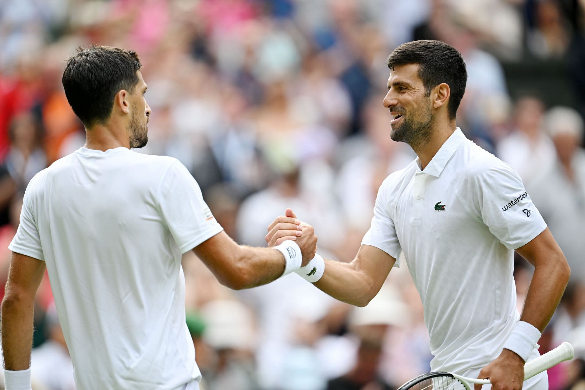 Pedro Cachin shakes hands with Novak Djokovic at Wimbledon 2023