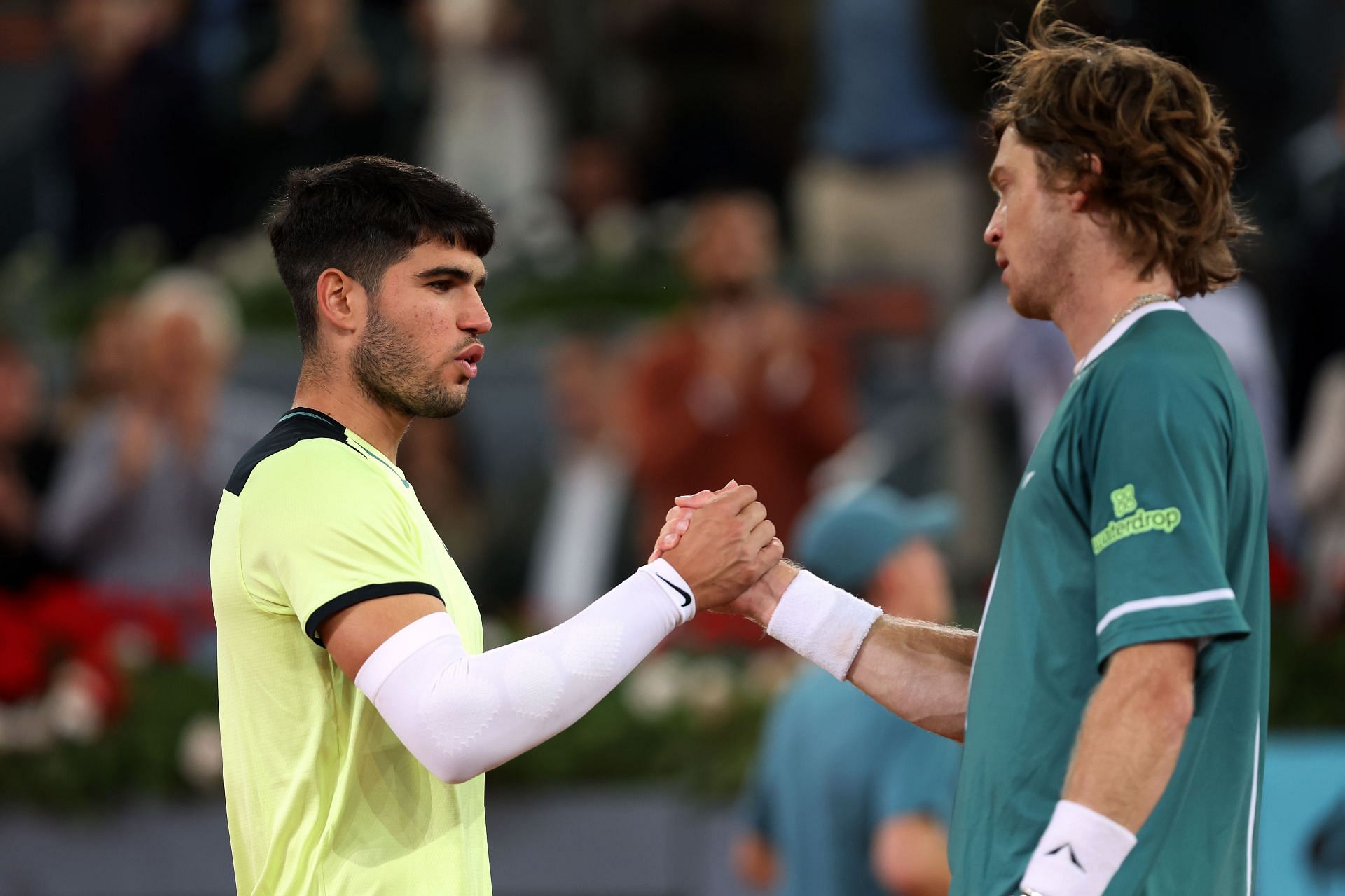 Carlos Alcaraz (L) and Andrey Rublev (R) shake hands at the net after the conclusion of their 2024 Madrid Open quarterfinal