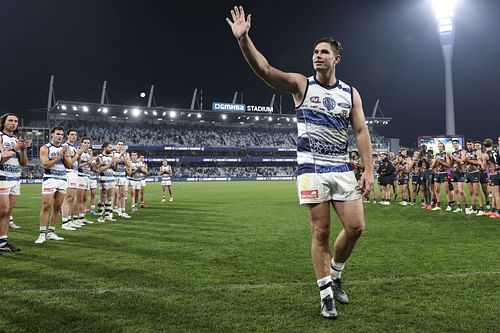 Tom Hawkins of the Cats leaves the ground after breaking the appearances record for the Cats