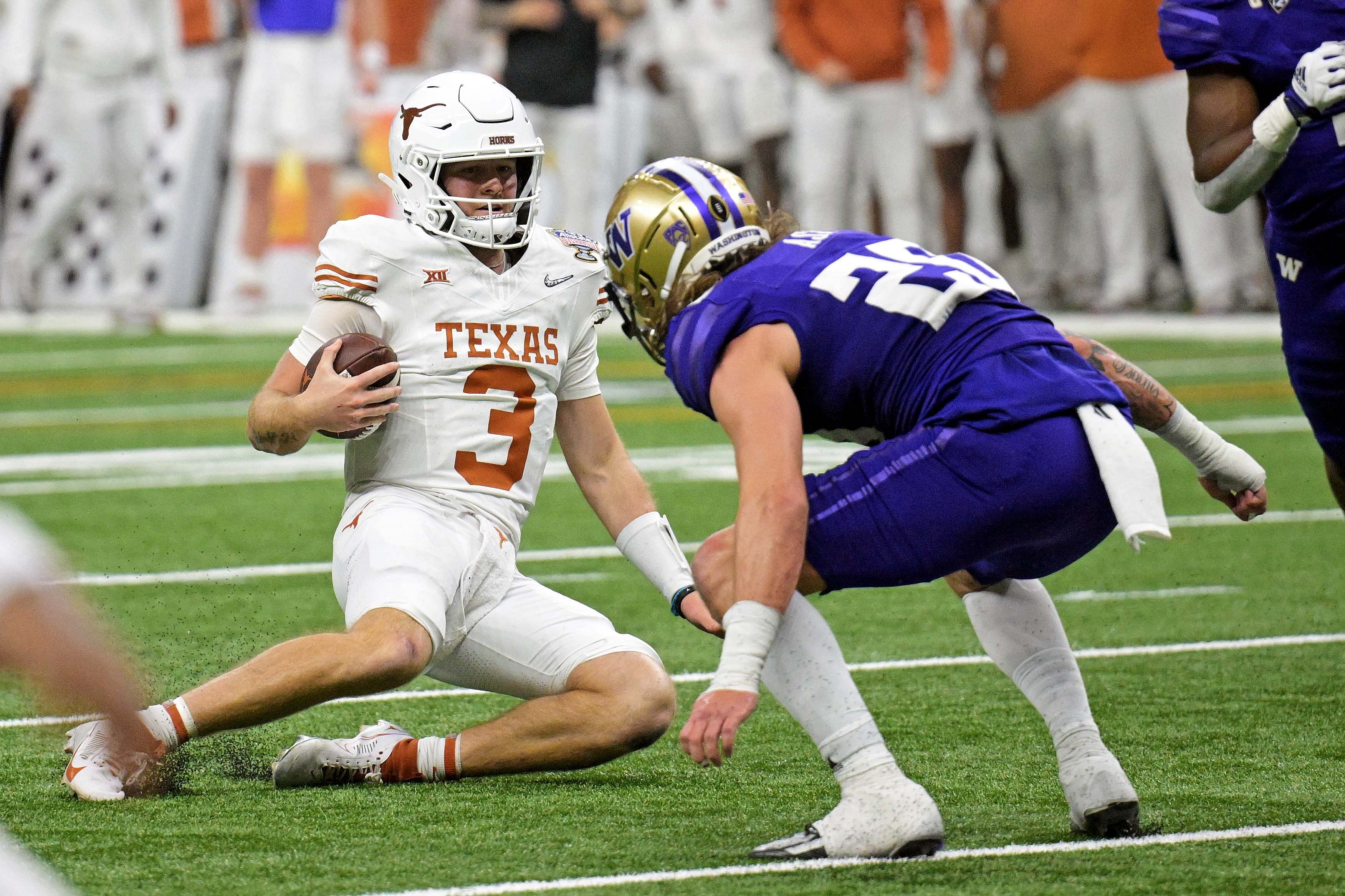 Texas Longhorns quarterback Quinn Ewers (3) slides after a run.