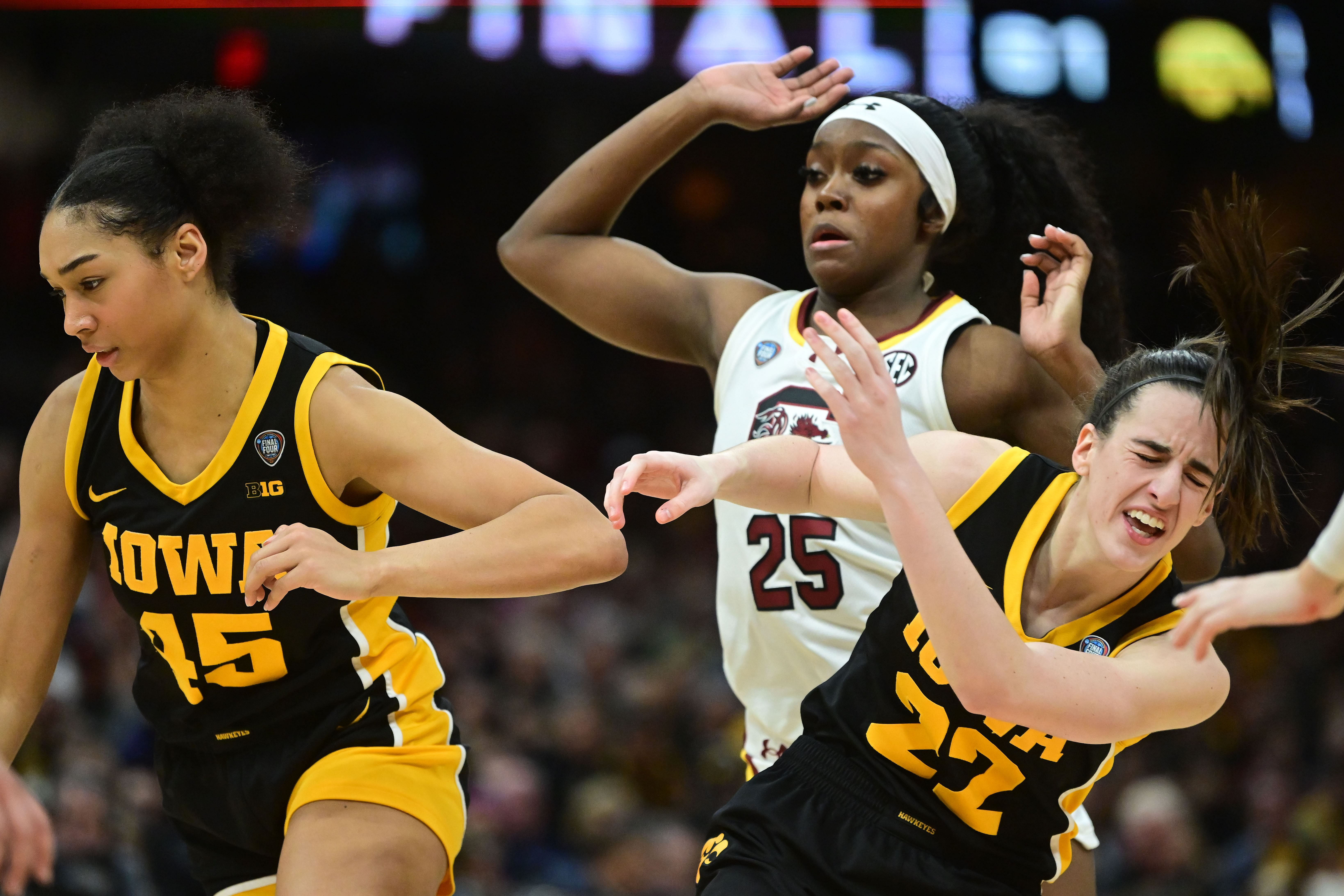 South Carolina Gamecocks guard Raven Johnson (25) and Iowa Hawkeyes guard Caitlin Clark (22) collide on the court in the finals of the Final Four of the women&#039;s 2024 NCAA Tournament.