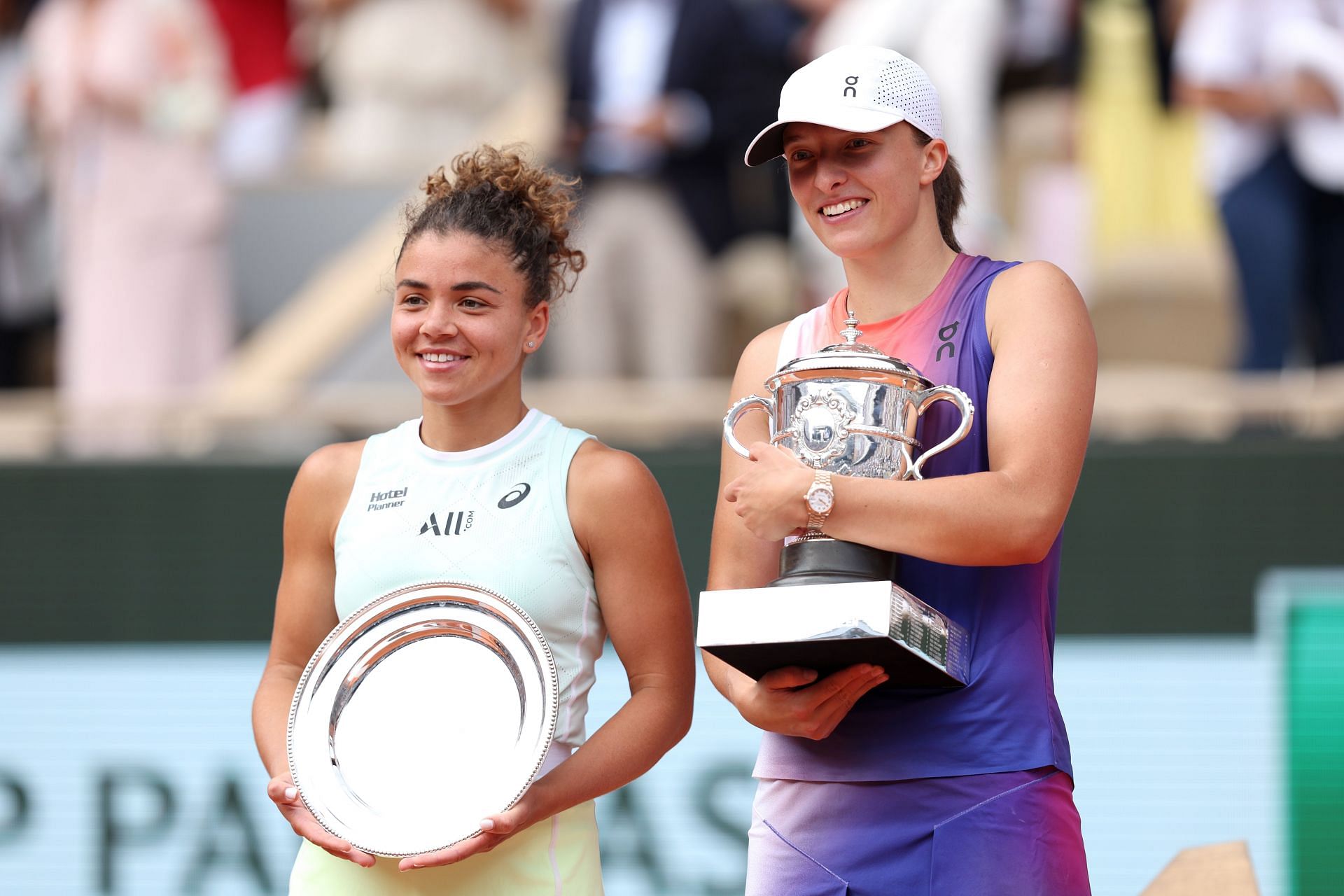 Jasmine Paolini (L) and Iga Swiatek with the 2024 French Open trophies.