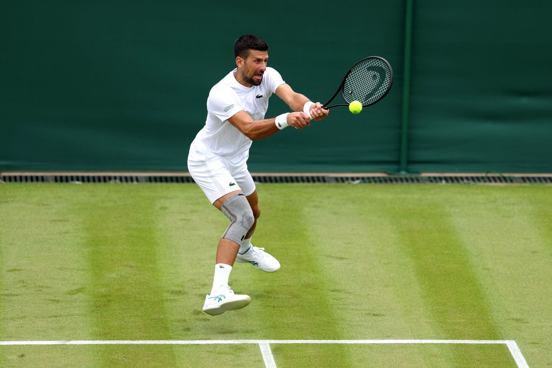 The Serb practicing with his knee strapped at Wimbledon 2024