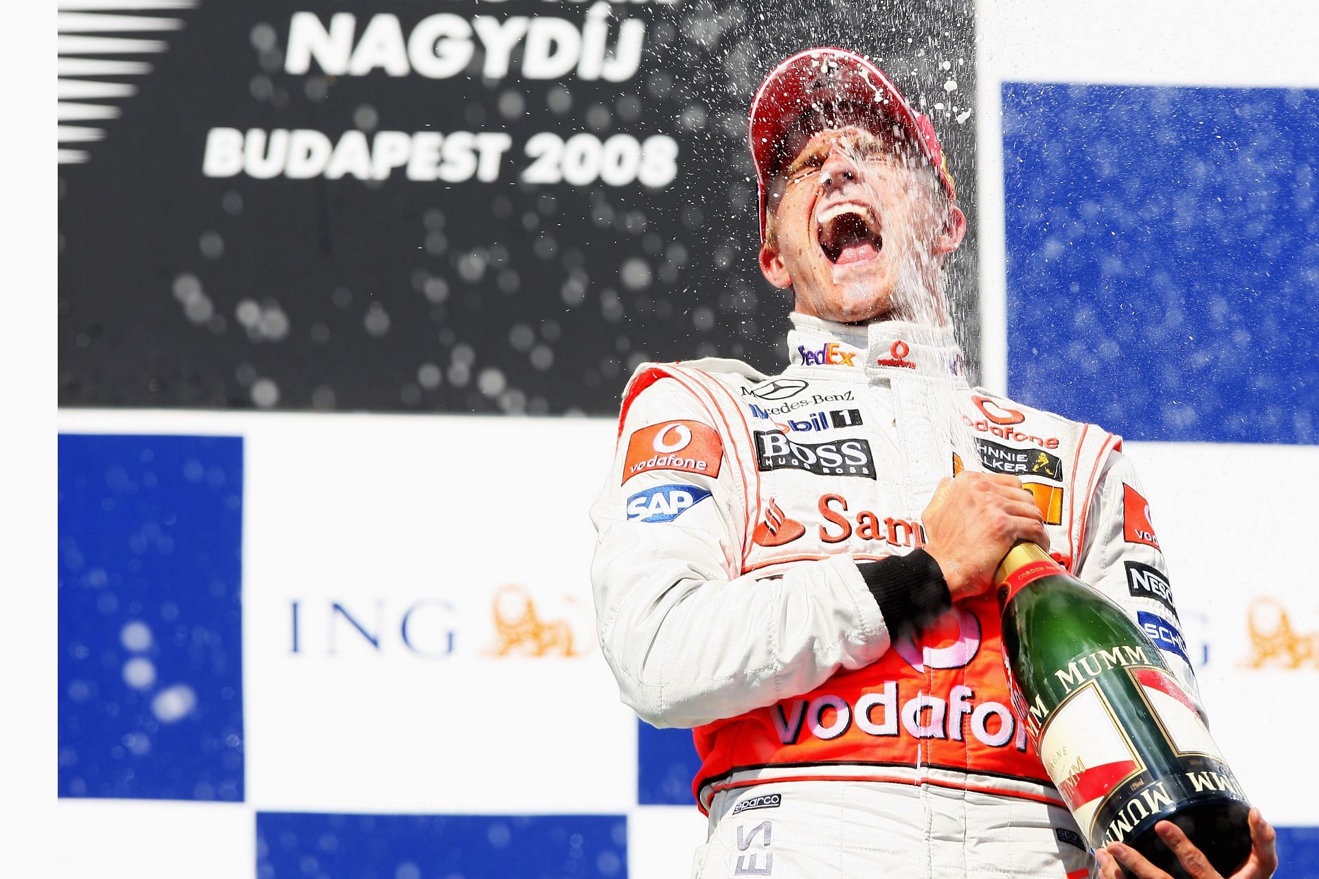 Heikki Kovalainen of Finland and McLaren Mercedes celebrate with champagne on the podium following his victory - Getty Images