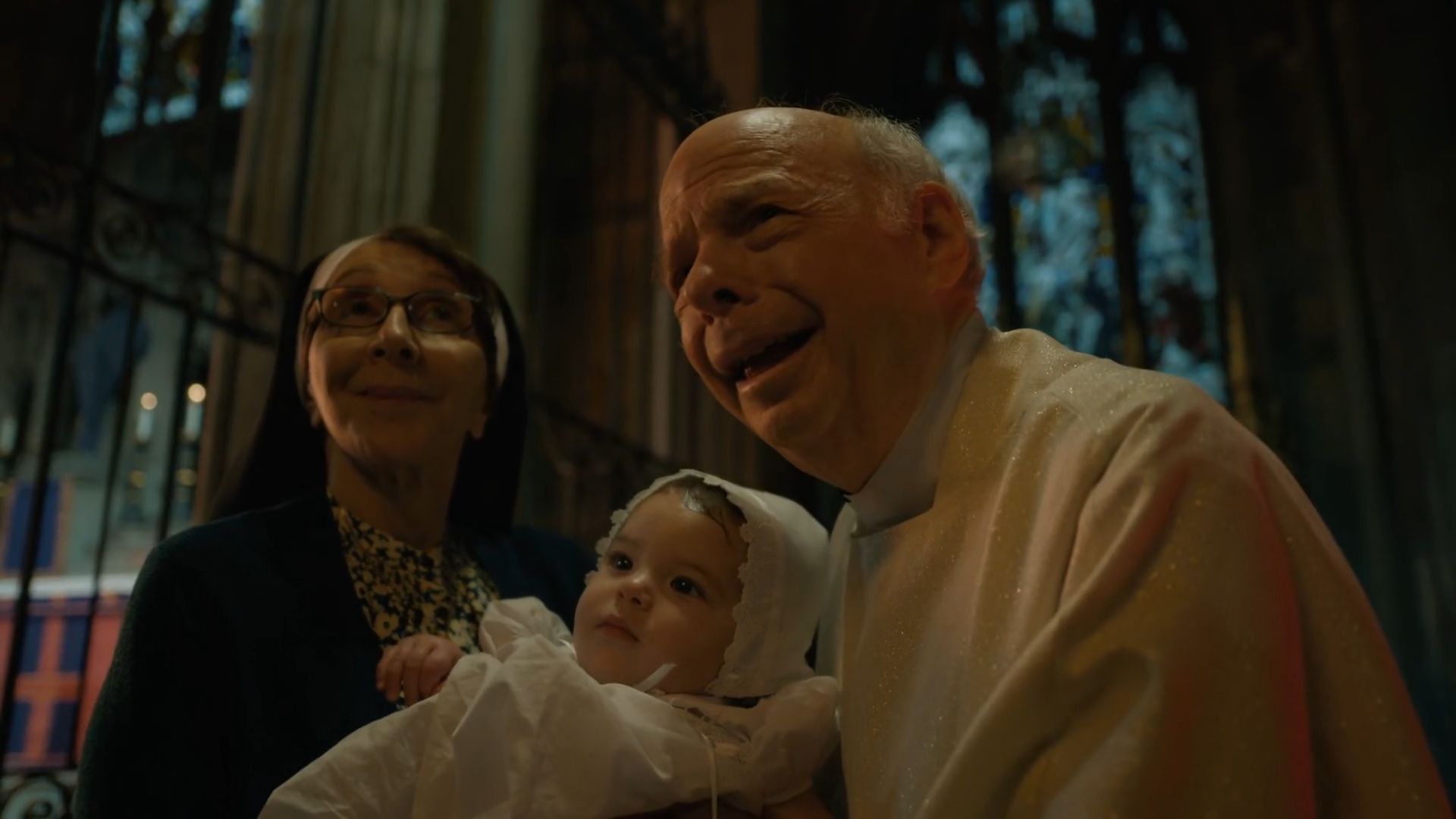 Father Ignatius and Sister holding Timothy after the baptism, as seen in Evil season 4 episode 8 (Image via Paramount+)