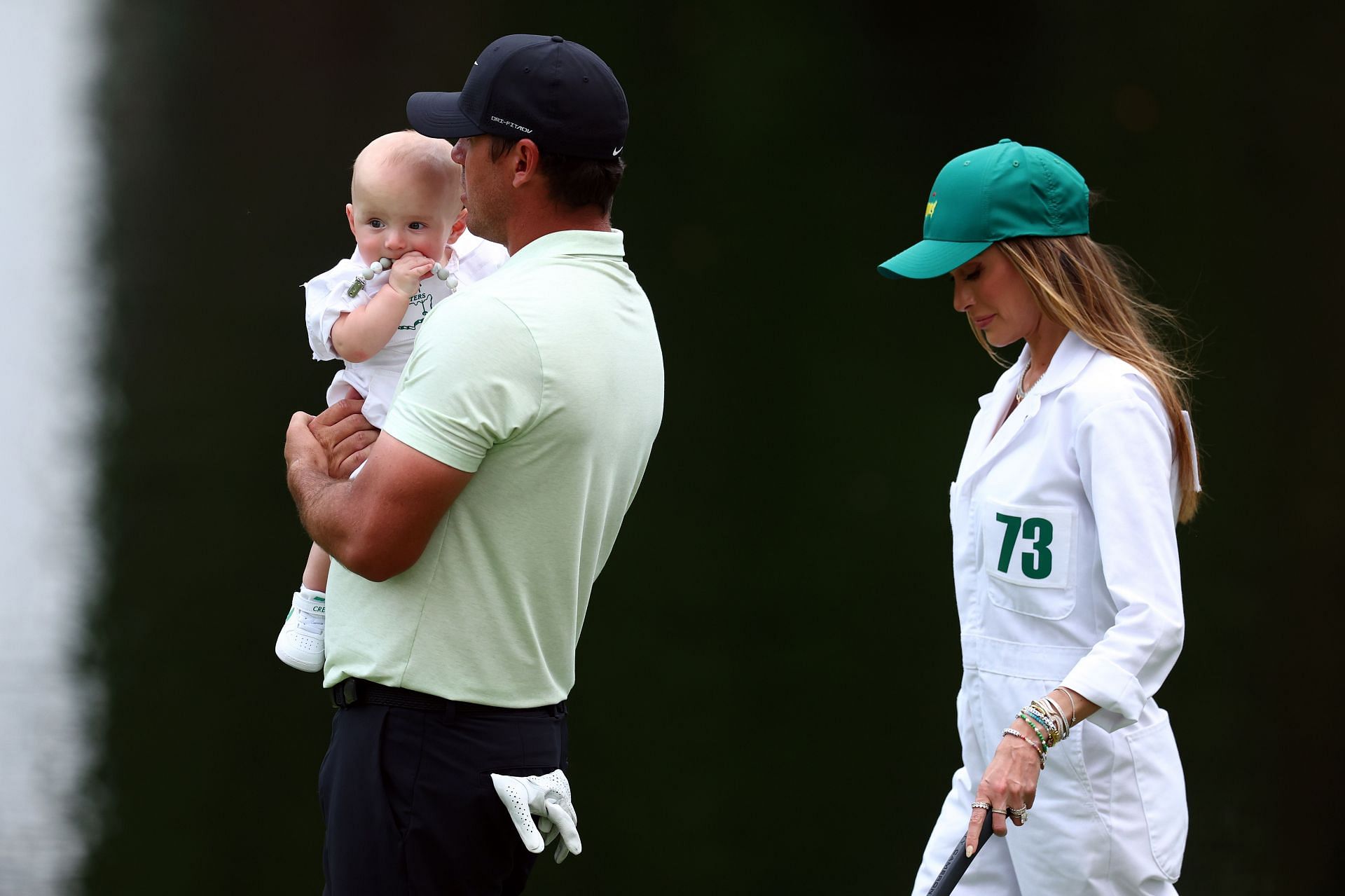 Brooks Koepka with Jena Sims and son Crew at the Masters (Image via Getty)